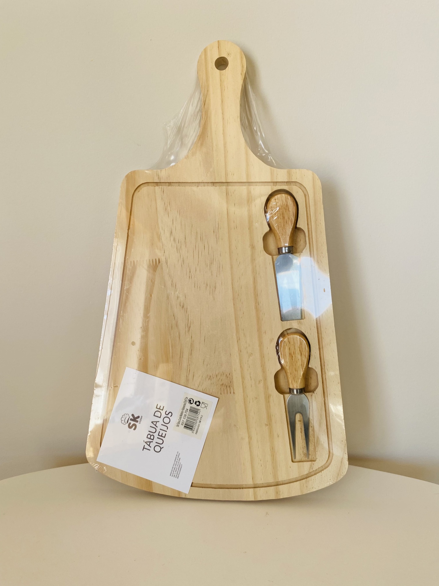 Tábuas de madeira com dois utensílios para queijo embalada