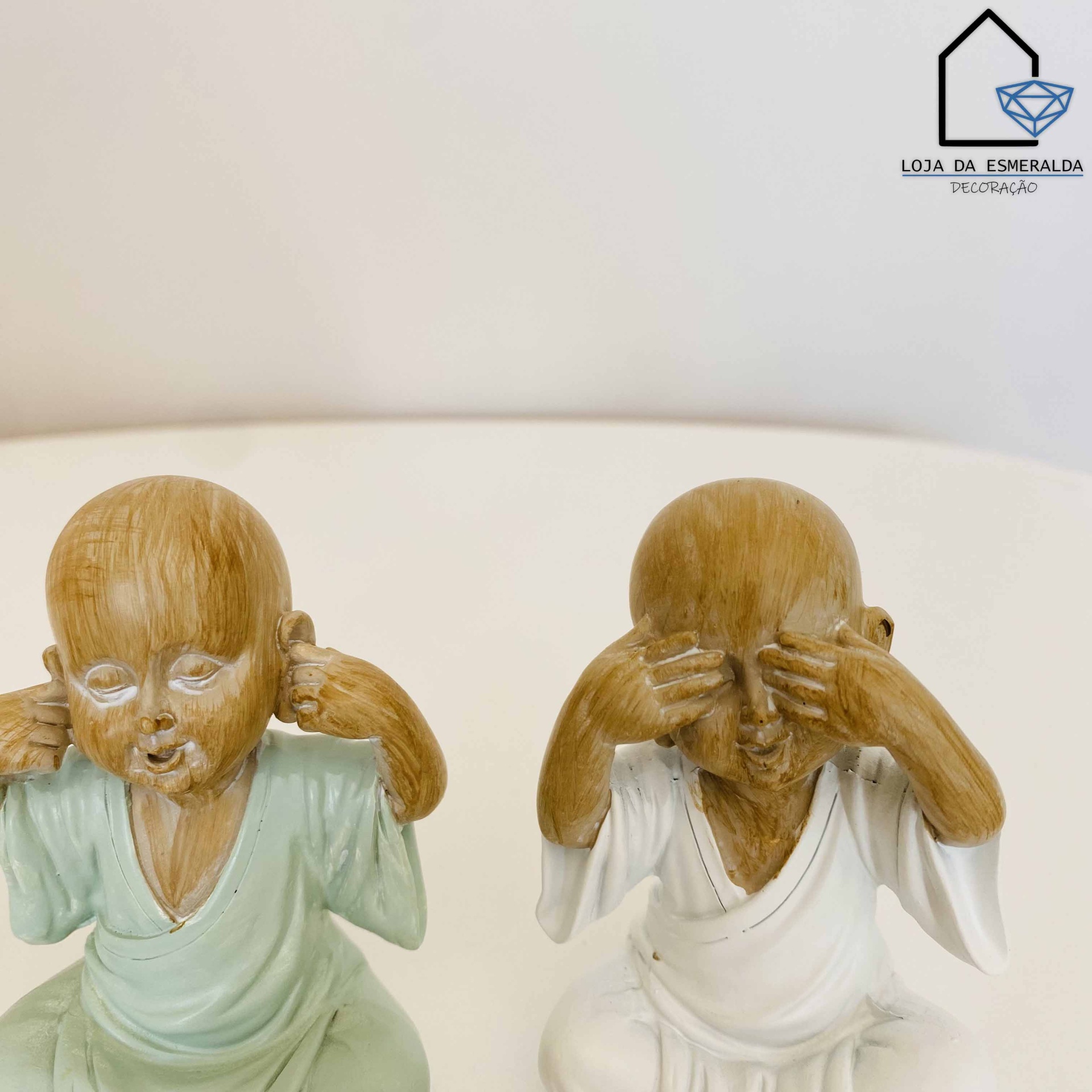 Estatuetas decorativas de crianças em roupas tradicionais tapando orelhas e olhos