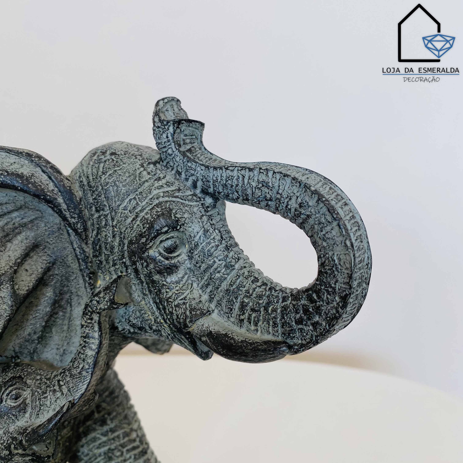 Escultura de elefante cinza com textura, logotipo Loja da Esmeralda Decoração no fundo branco