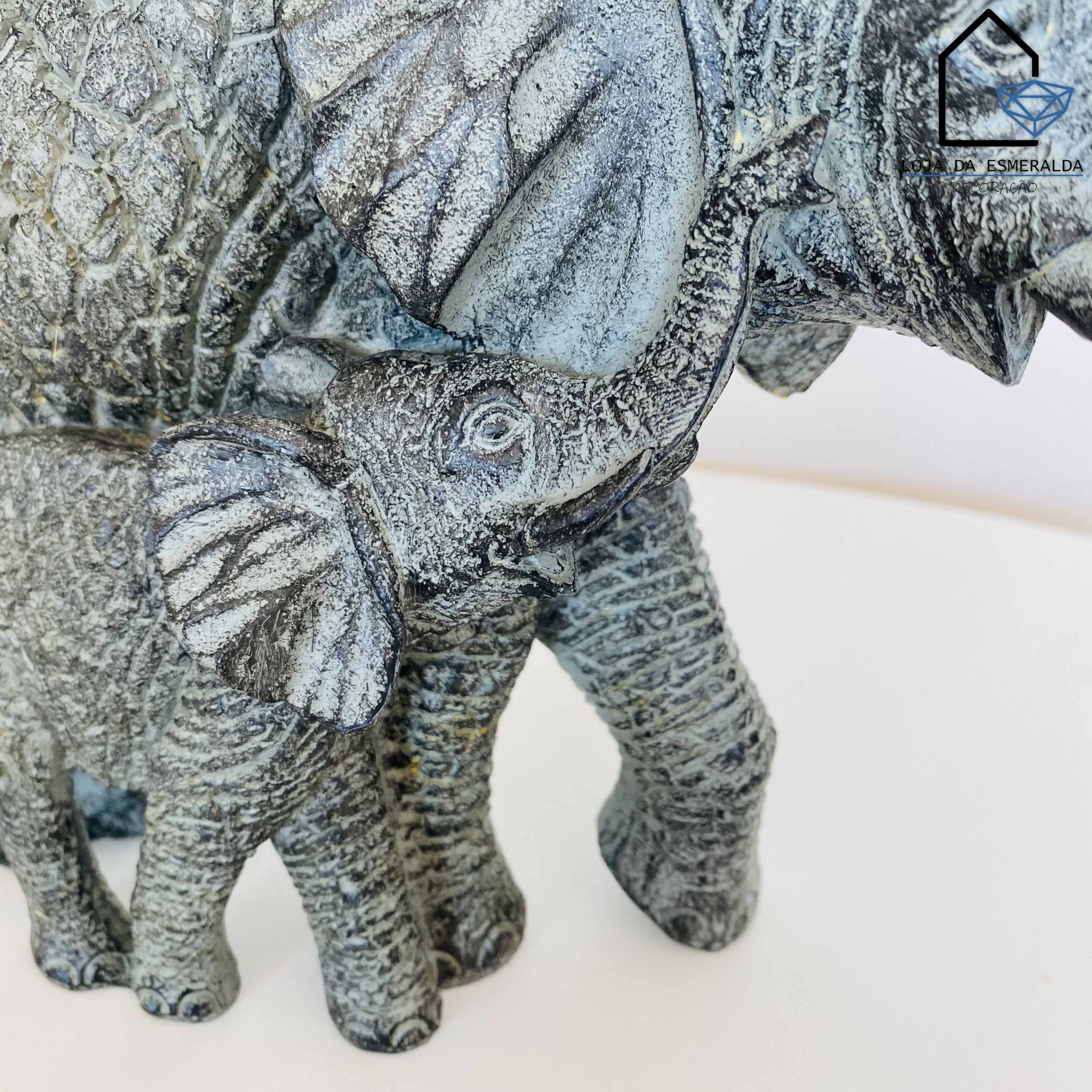 Estatueta de elefantes em pedra cinza com textura rugosa