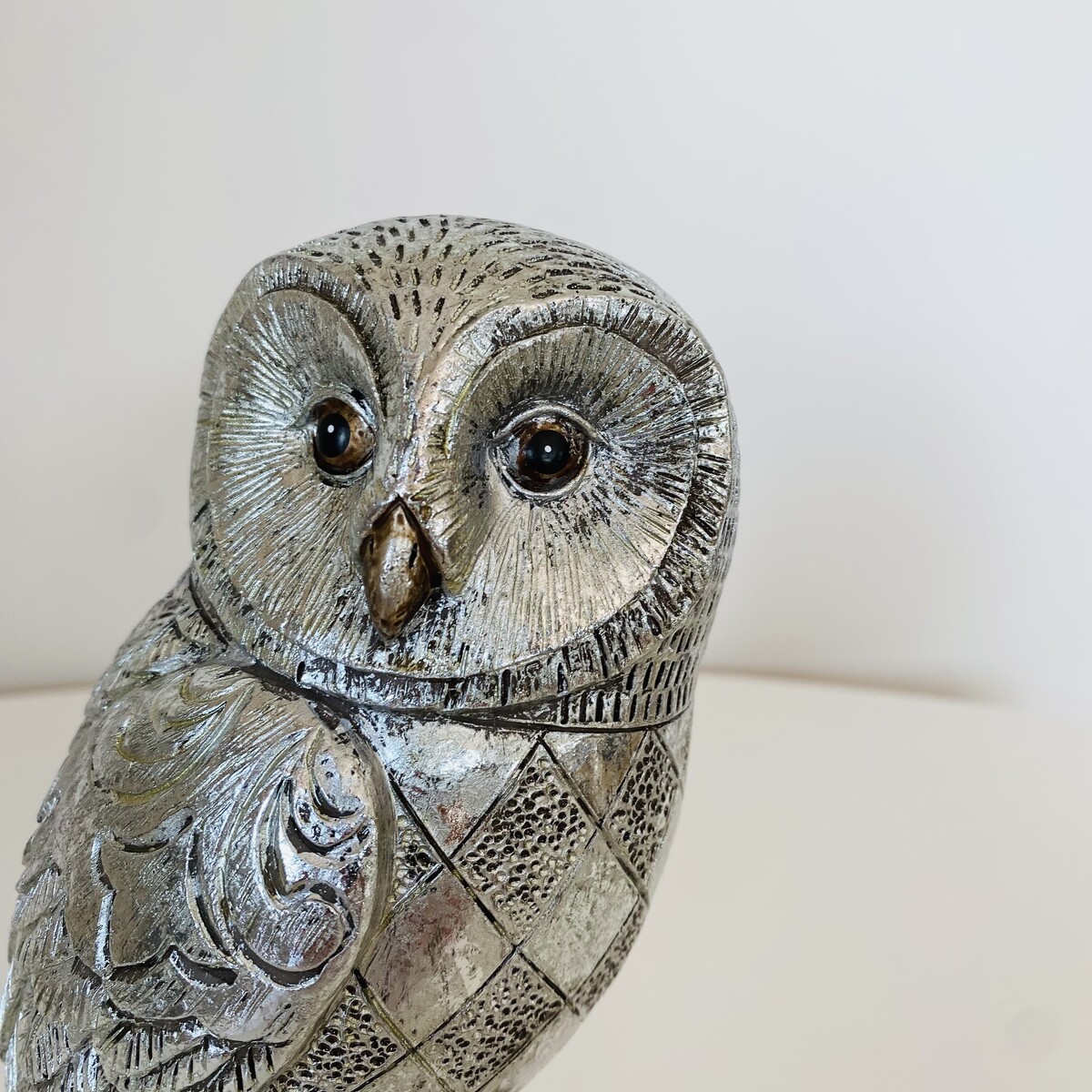 Estátua decorativa de coruja prateada com textura detalhada