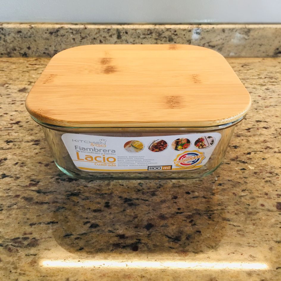 Recipiente de vidro com tampa de bambu sobre bancada de granito