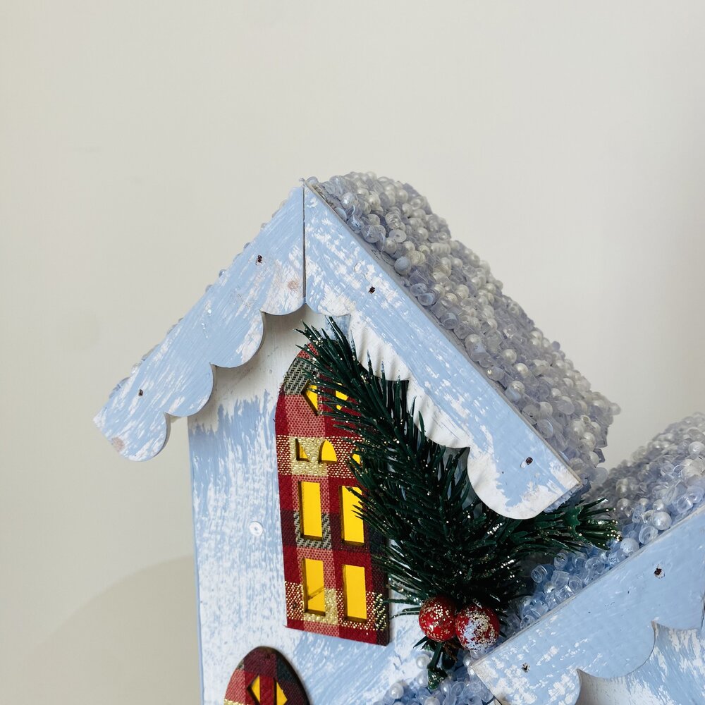 Casinha decorativa de madeira azul claro com detalhes de neve e raminho verde e bagas vermelhas