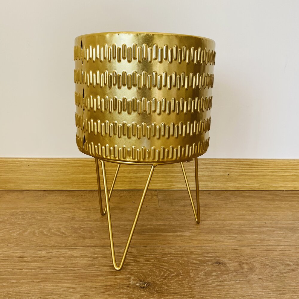 Vaso metálico dourado com padrão recortado e suporte de três pernas