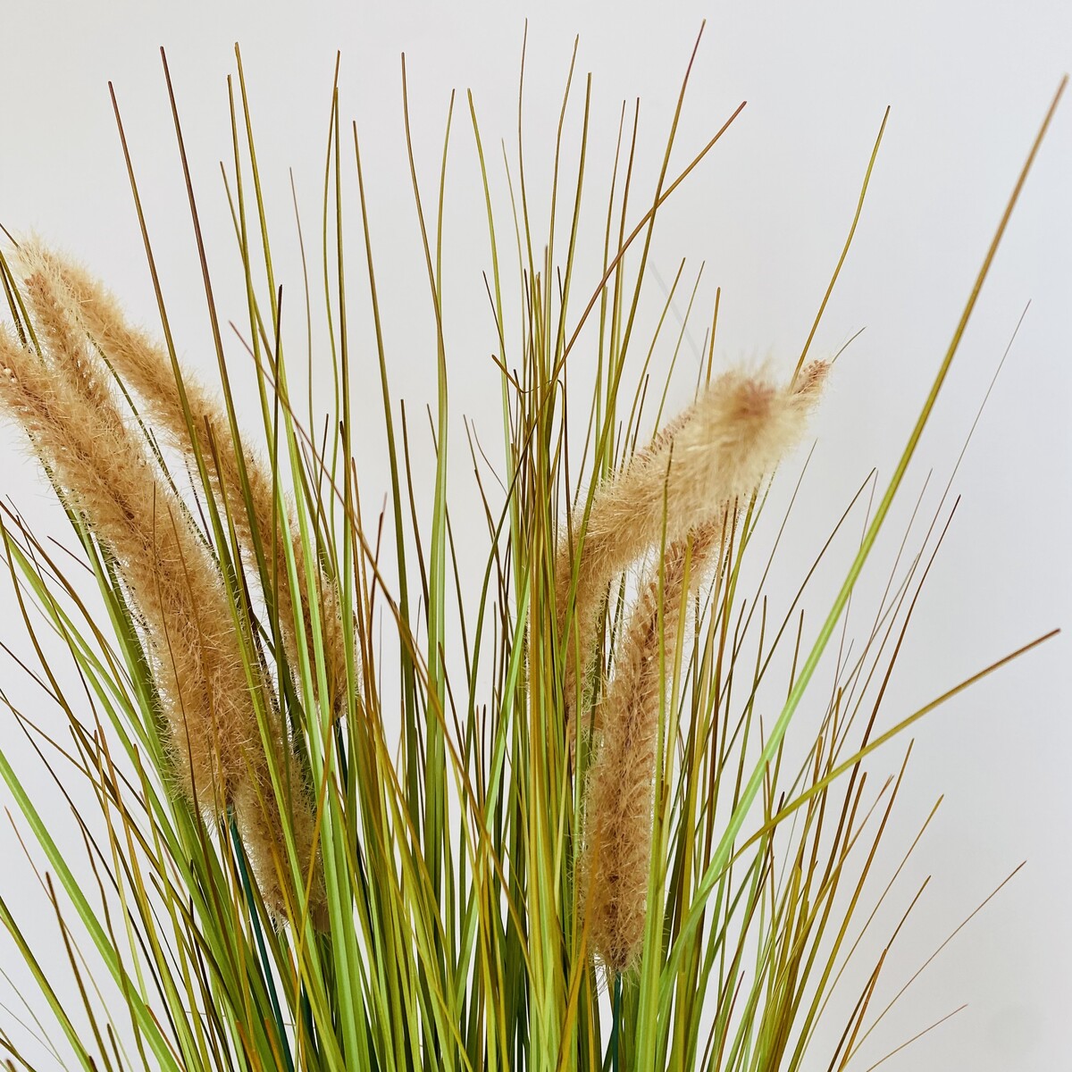 Planta artificial com folhas verdes e flores felpudas bege