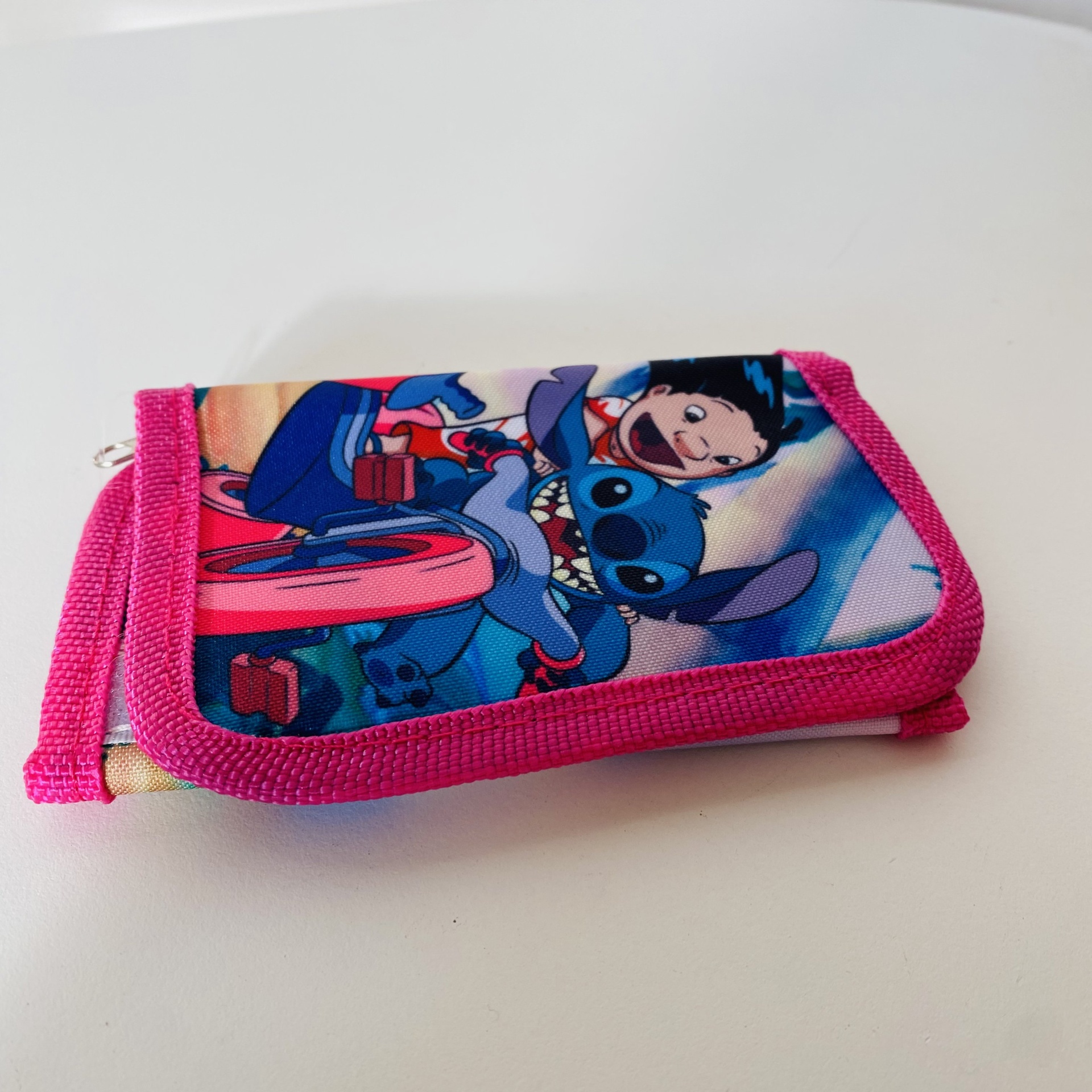 Carteira rosa com estampa de Stitch e menina em bicicleta