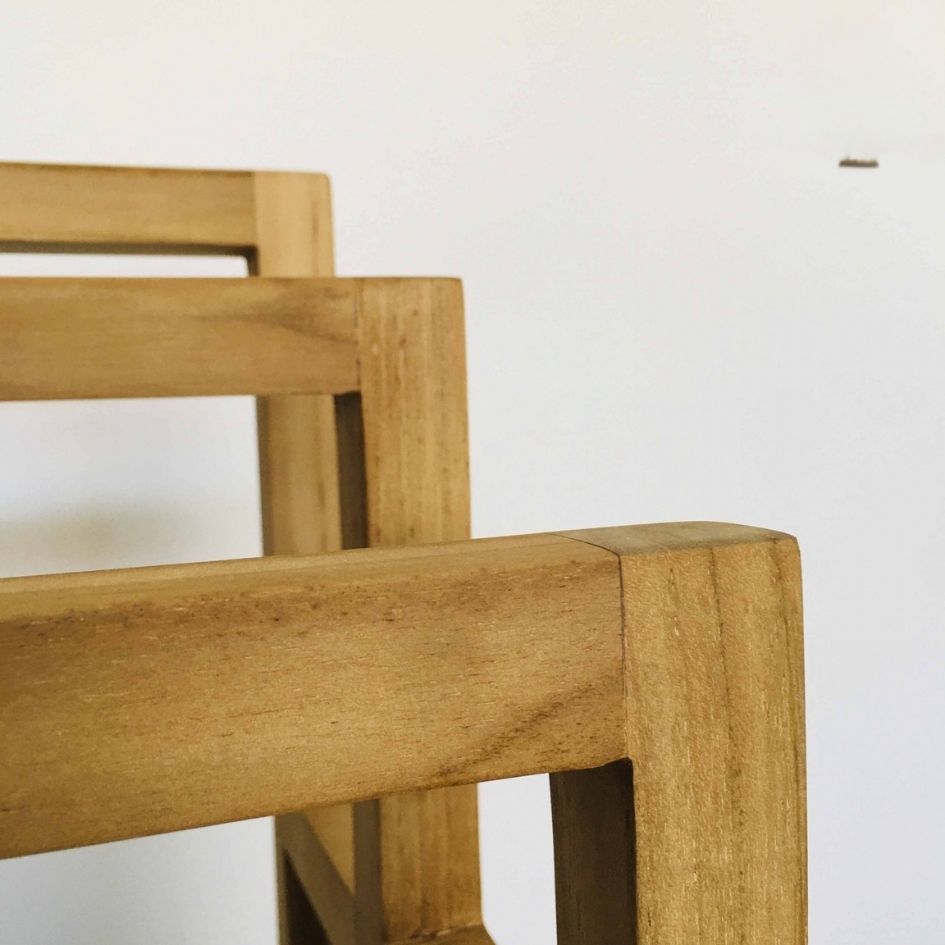 Detalhe em madeira clara de cadeiras com juntas e textura visível