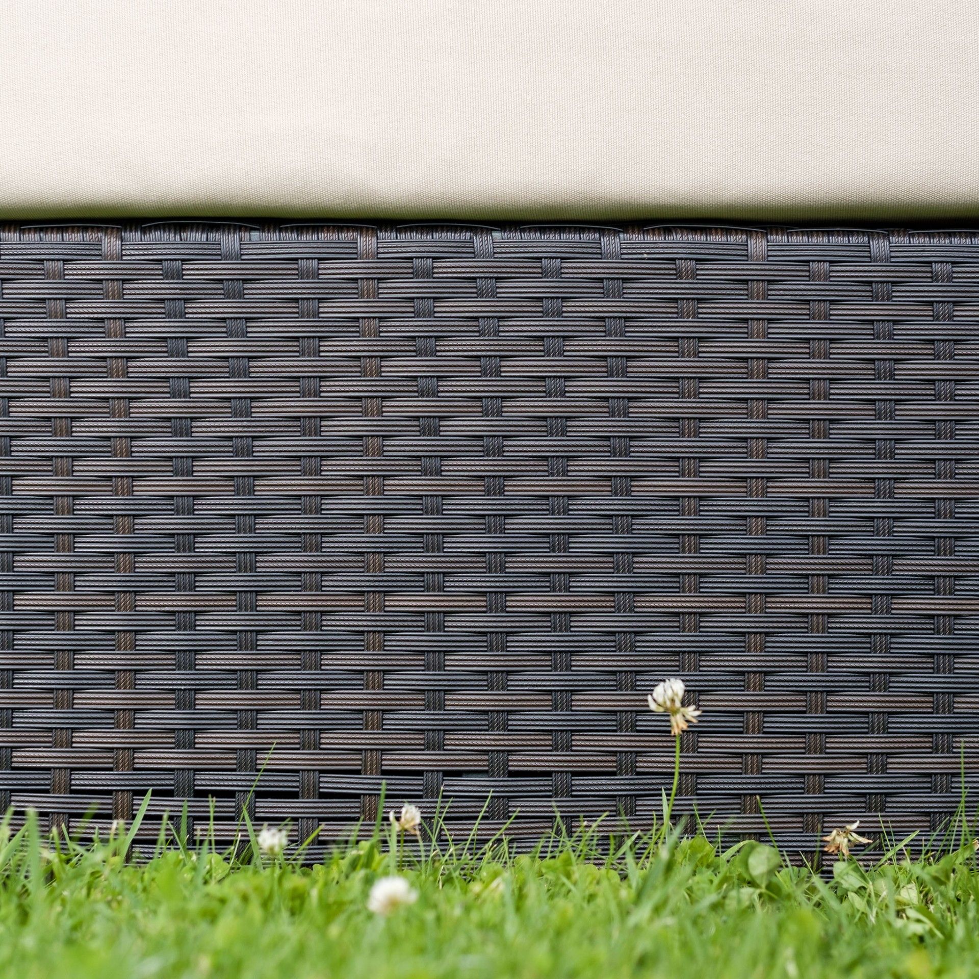 Estrutura de vime sintético preto com almofada clara e relva