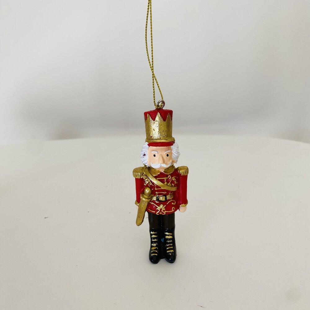 Figura decorativa de soldado com casaco vermelho e dourado suspensa
