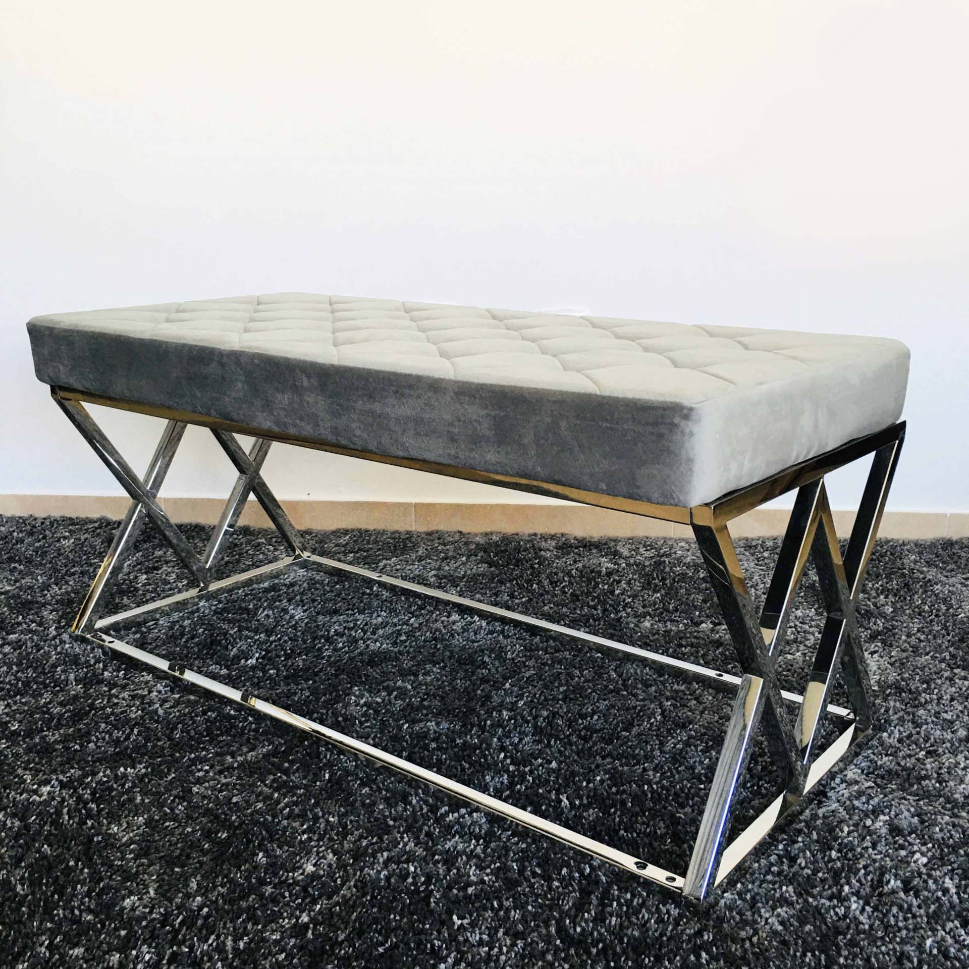 Banco em metal cromado com assento almofadado cinzento em tapete preto