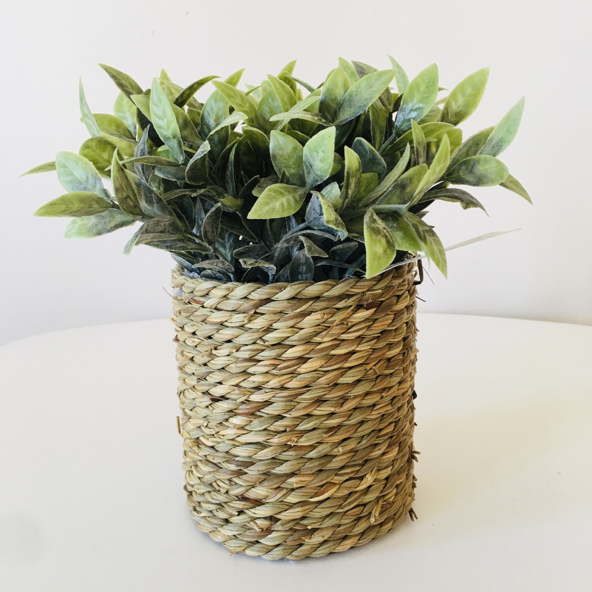 Vaso trançado com planta artificial de folhas verdes