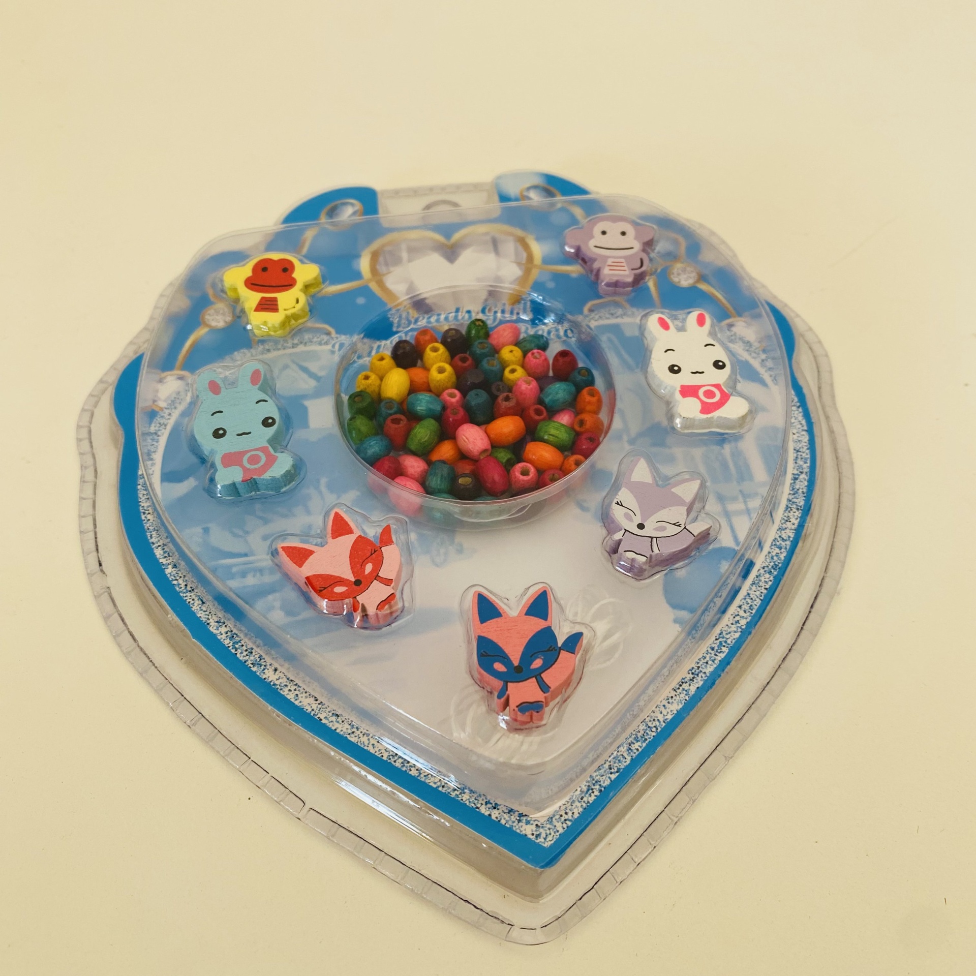 Brinquedo em forma de coração azul com contas coloridas e ícones de animais