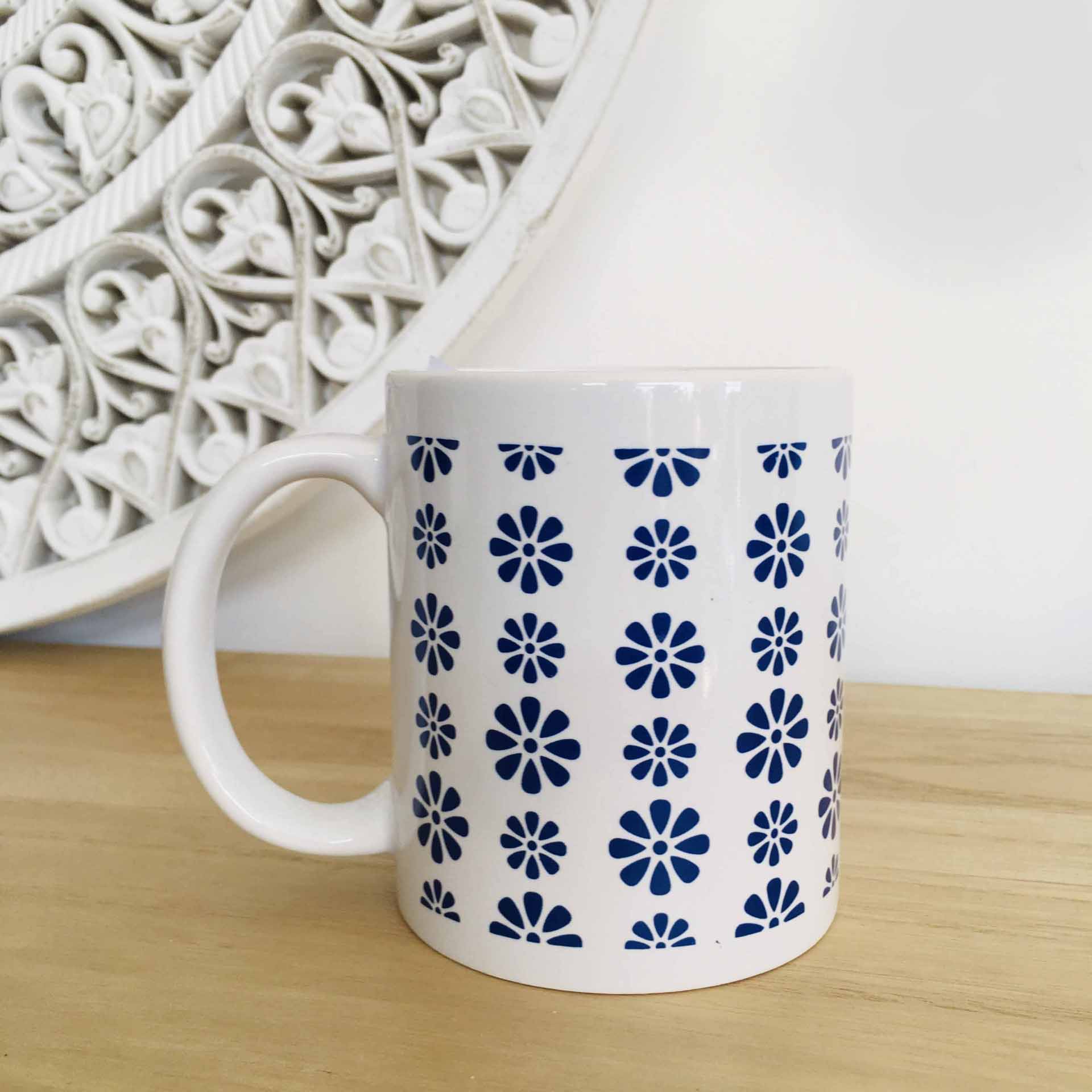 Caneca branca de cerâmica com padrão de flores azuis
