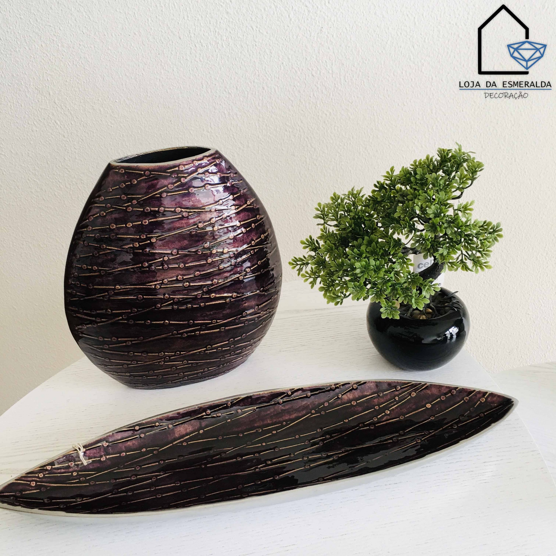 Conjunto de vasos decorativos pretos com riscas douradas e planta artificial verde