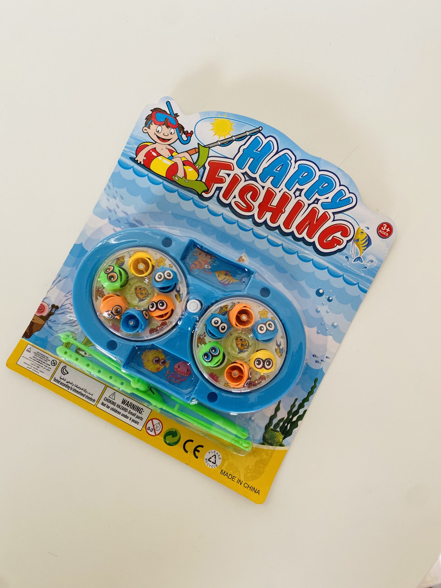 Jogo infantil Happy Fishing com peixes coloridos em embalagem azul com tema marinho