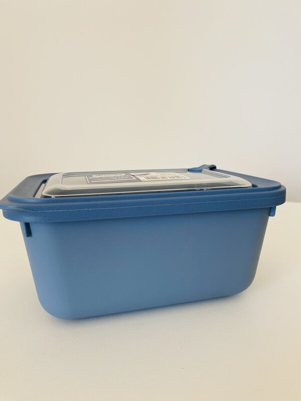 Recipiente plástico azul com tampa translúcida e etiqueta na tampa