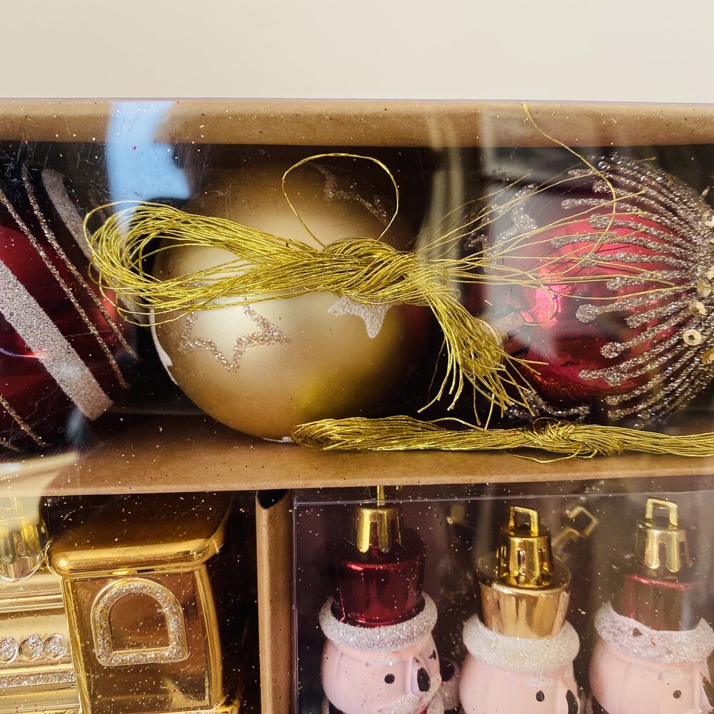 Bolas de Natal douradas e vermelhas em embalagem transparente