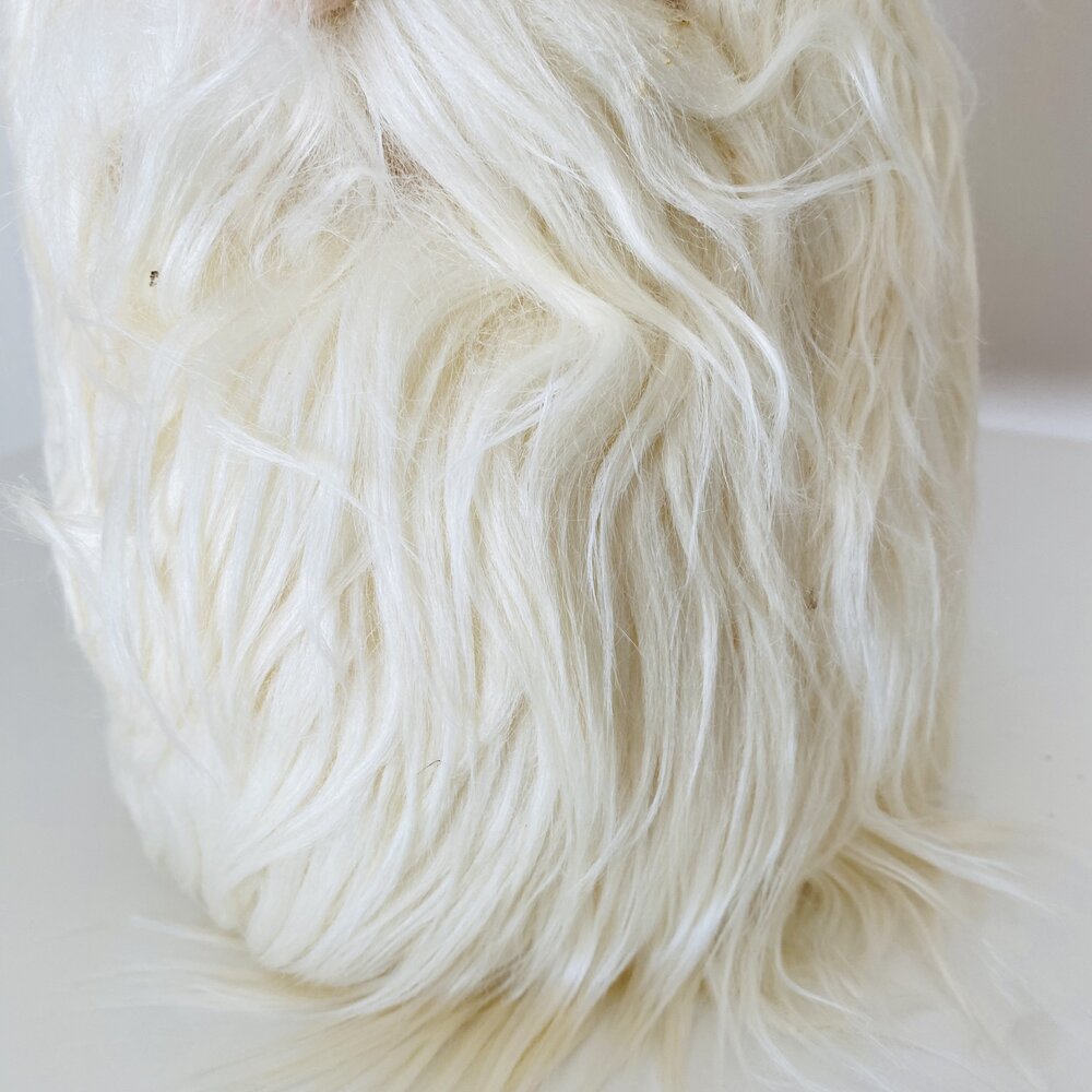 Objeto coberto com pelos brancos longos ondulados