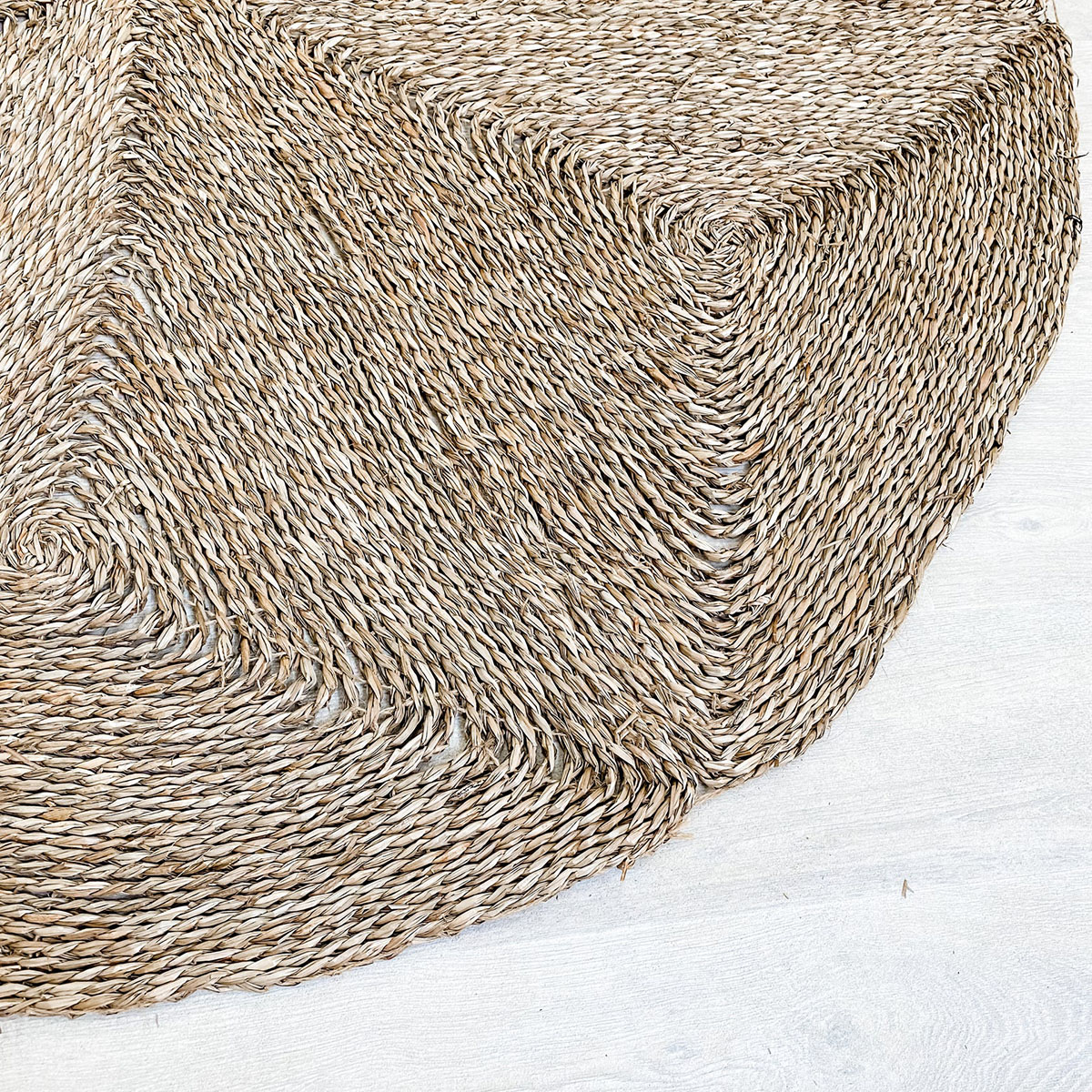 Tapete redondo trançado em fibras naturais bege e castanho