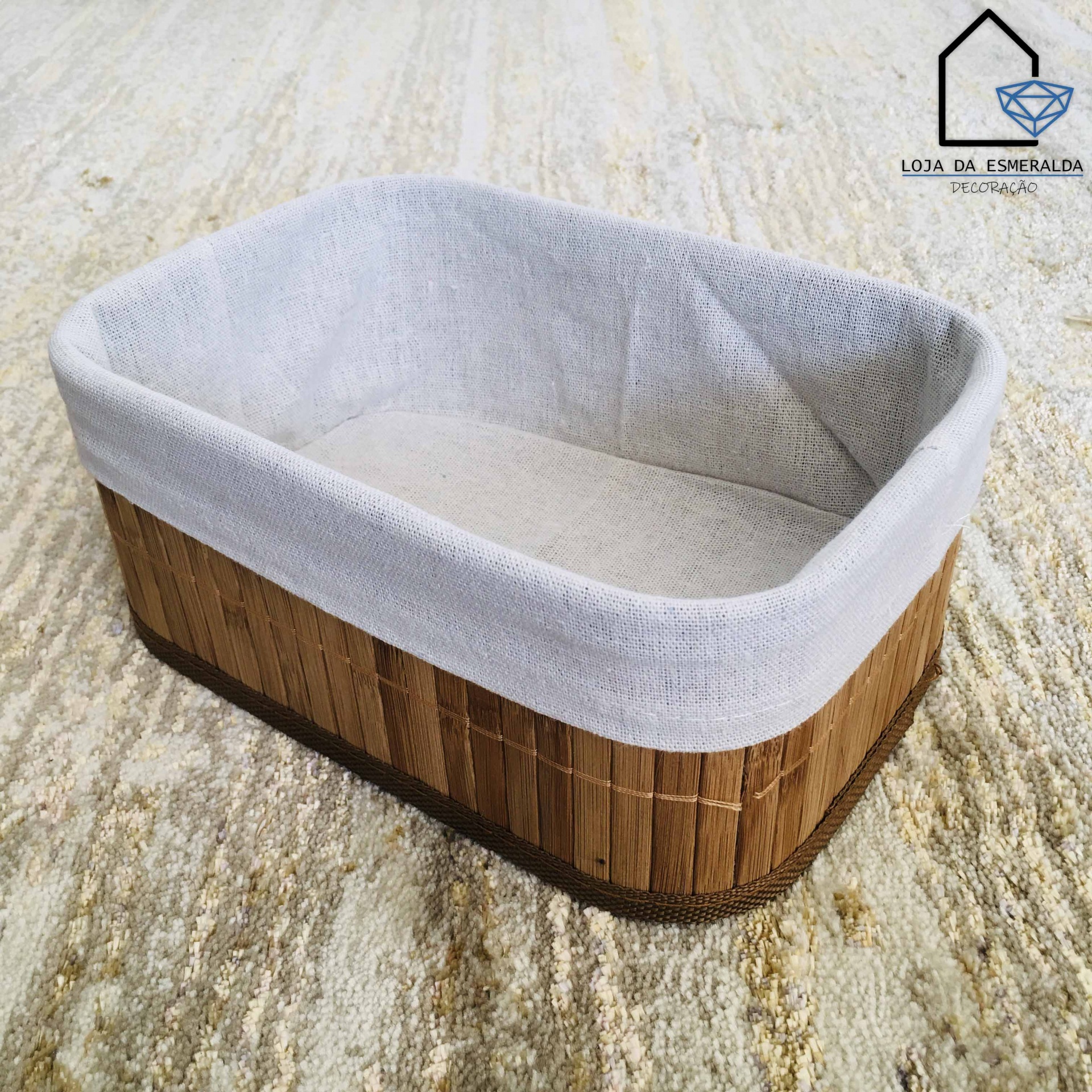 Cesto rectangular de madeira com forro cinzento sobre tapete neutro