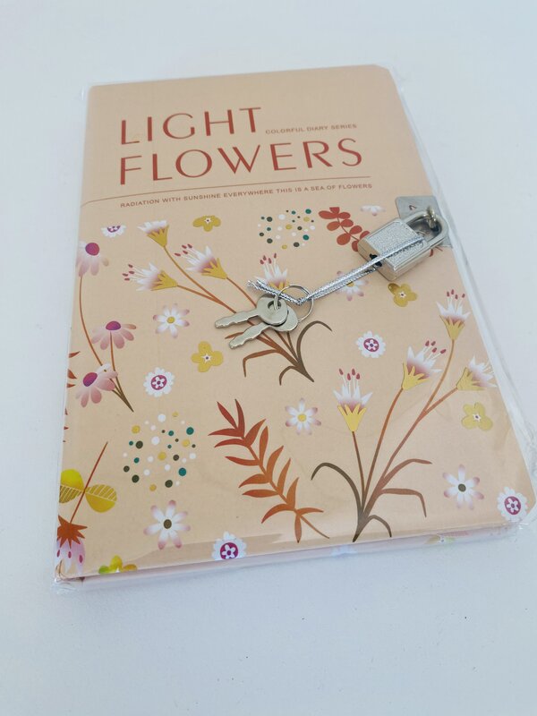 Caderno de capa rosa pêssego com flores coloridas e cadeado prateado com duas chaves