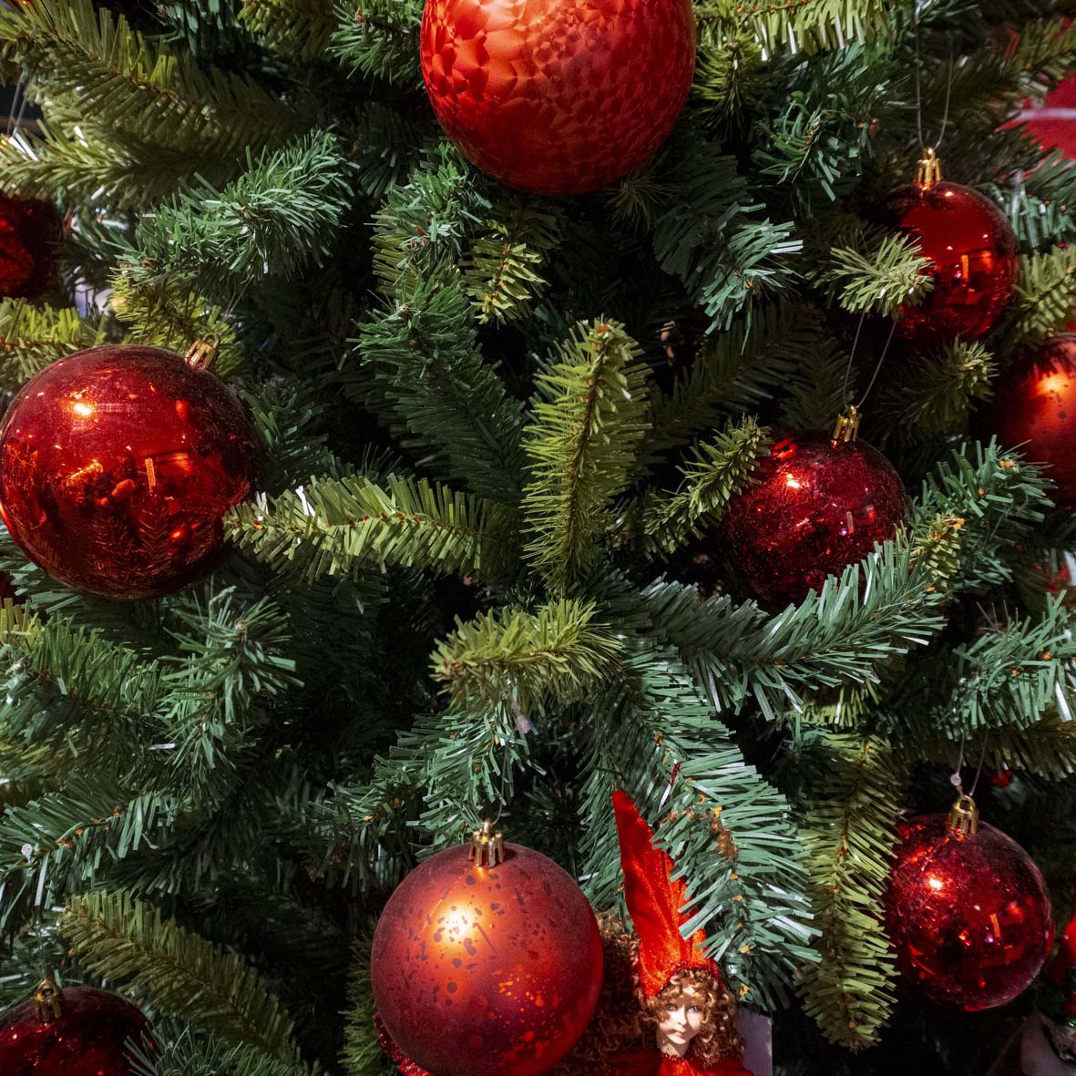 Árvore de Natal verde com bolas vermelhas e gnomo decorativo