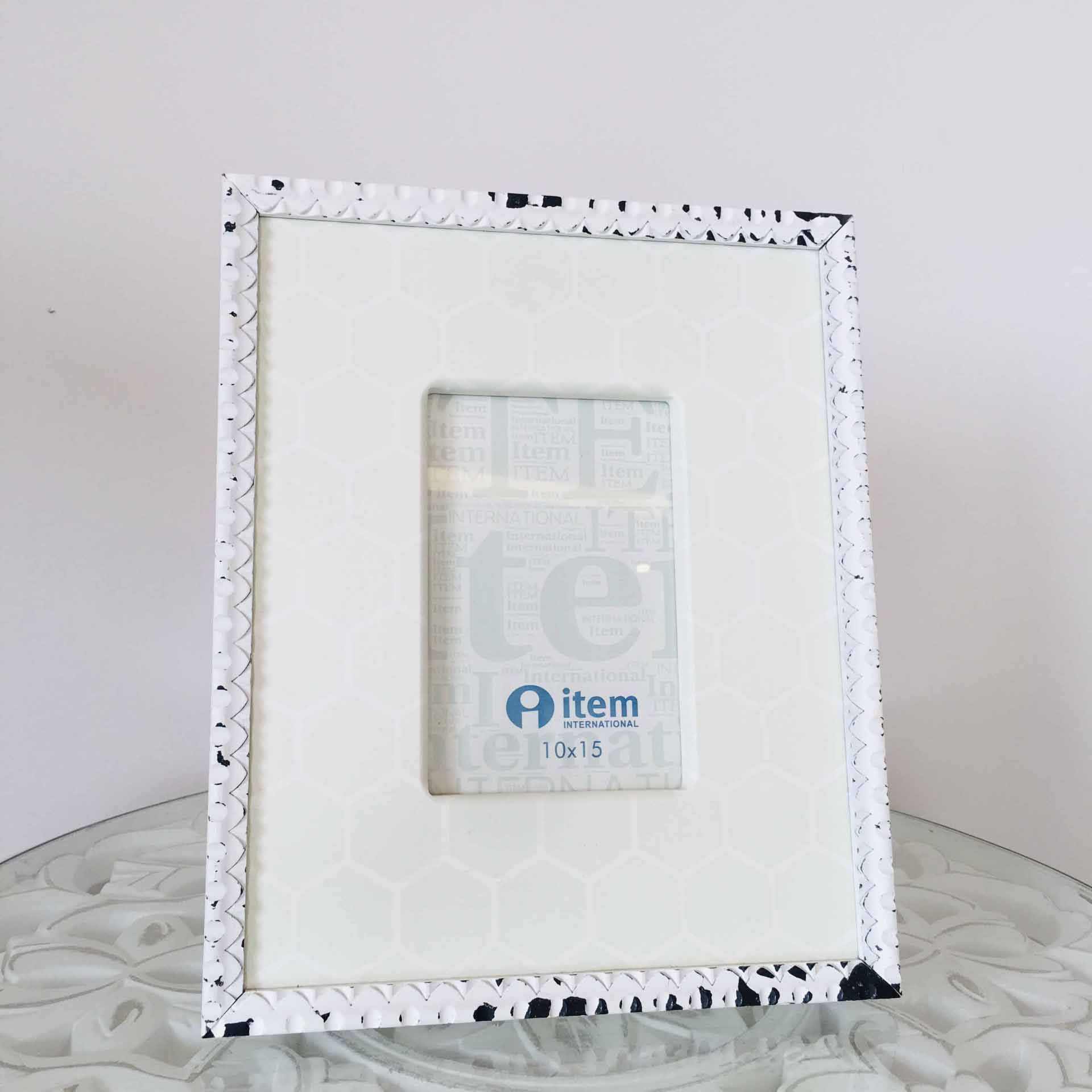 Estrutura de fotografia branca com padrão preto nas bordas e etiqueta 'item INTERNATIONAL 10x15'.