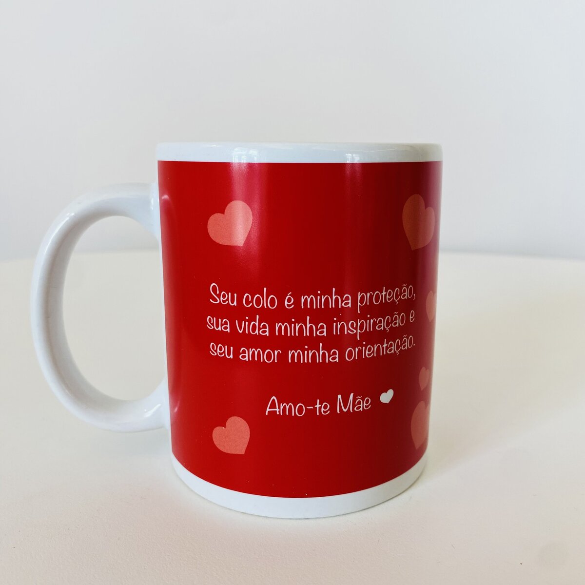 Caneca branca com exterior vermelho e texto em português dedicado à mãe.