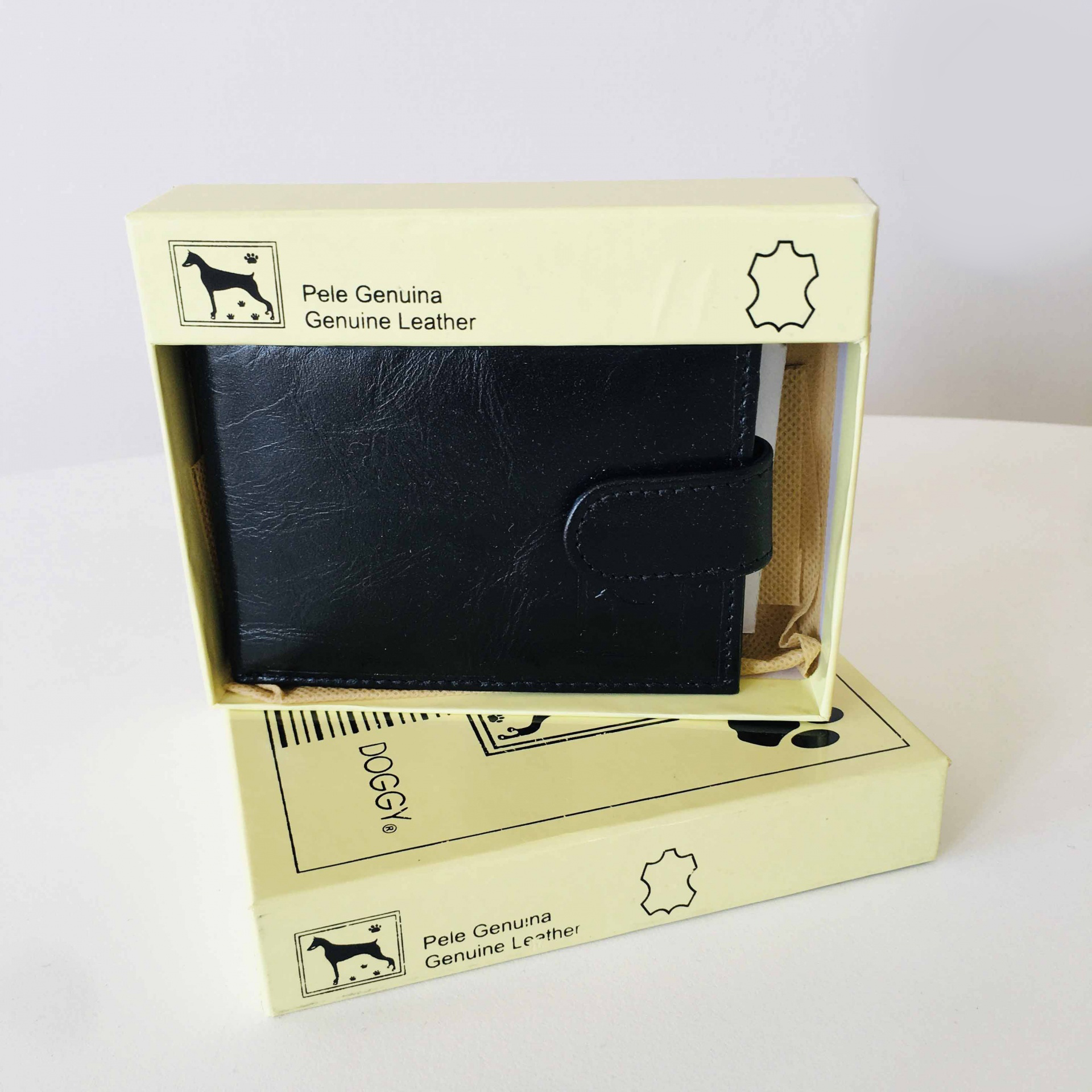 Carteira preta de pele genuína na caixa bege com texto Pele Genuína Genuine Leather