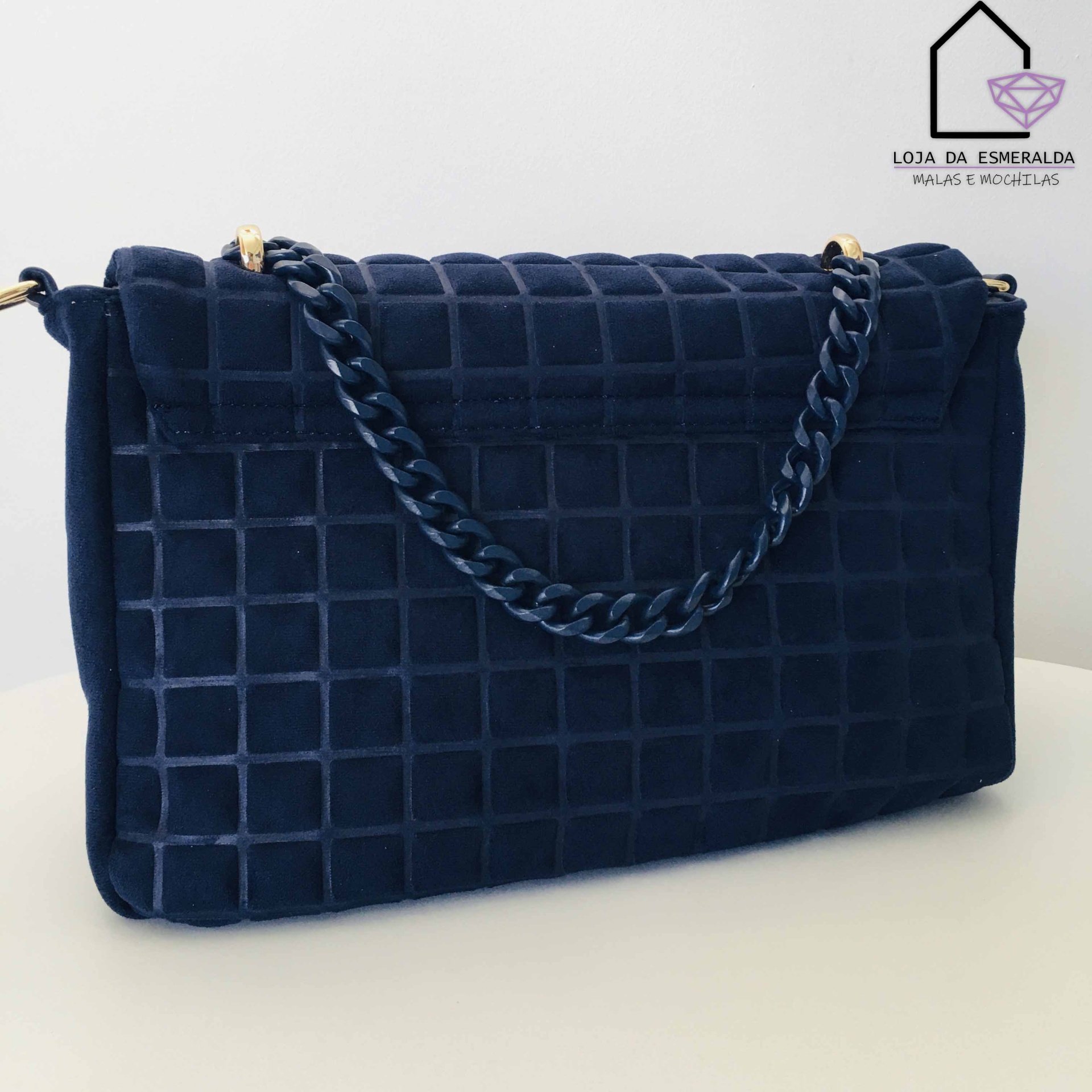 Mala azul escura com padrão de quadrados e alça de corrente