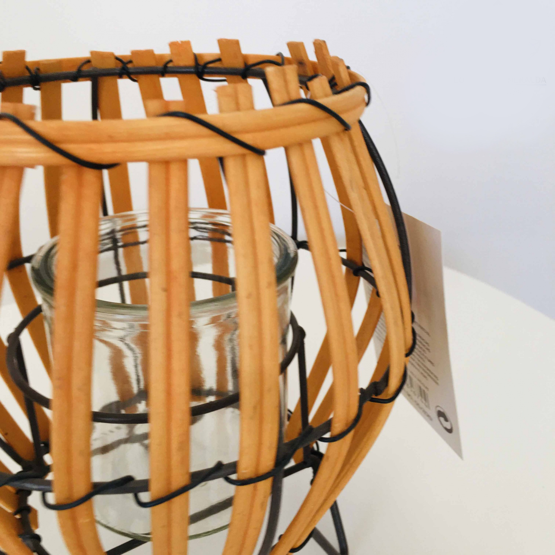 Castiçal de vidro com estrutura de madeira clara e suporte de arame preto