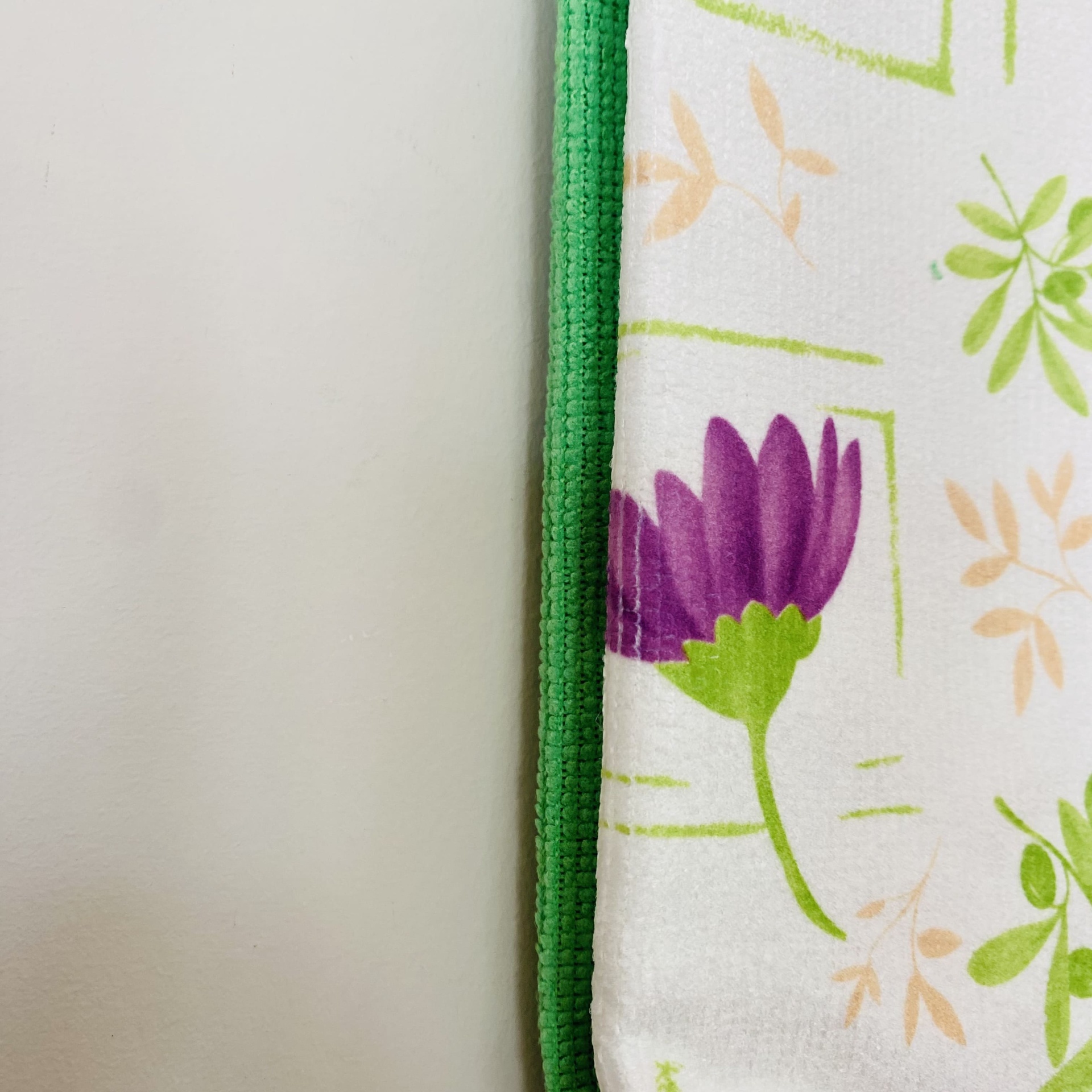 Toalha branca com padrão floral e borda verde