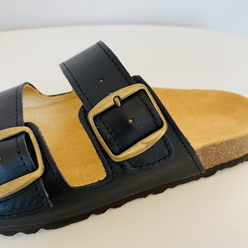 Sandália preta de duas tiras com fivelas douradas e sola castanha