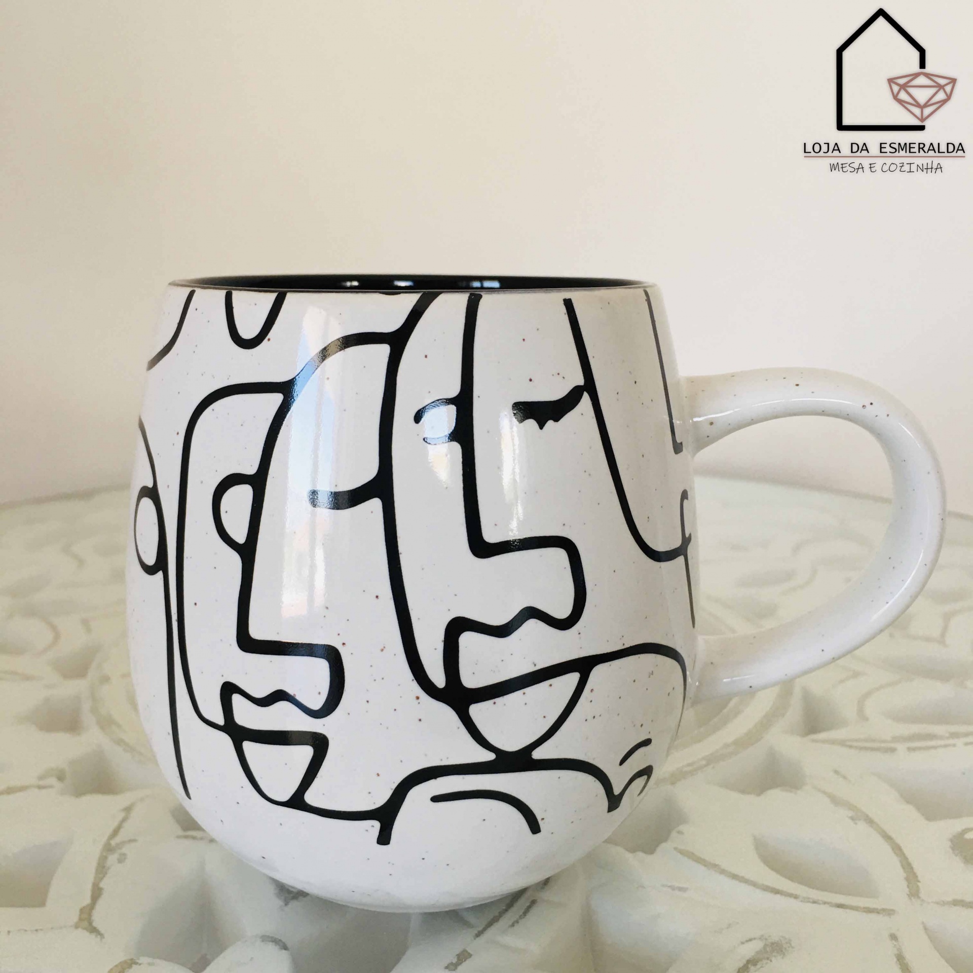 Caneca branca com padrão de faces em linhas pretas em cerâmica