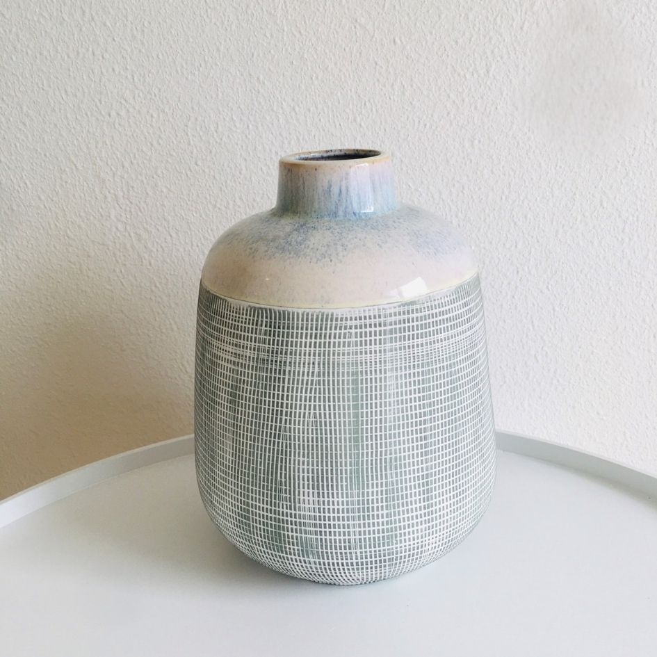 Vaso cerâmico cinza com padrão de linhas brancas e topo azul esbatido