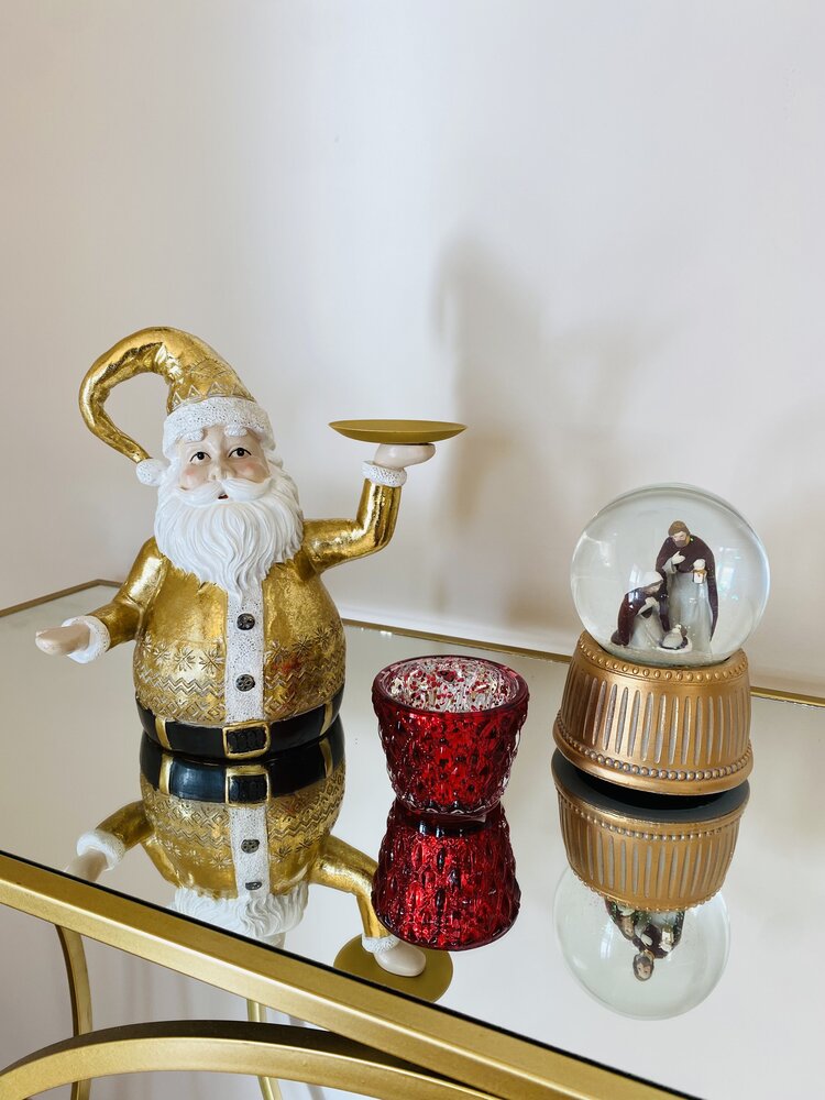 Decoração de Natal com boneco Pai Natal dourado, castiçal vermelho e bola de neve com base dourada e figuras dentro