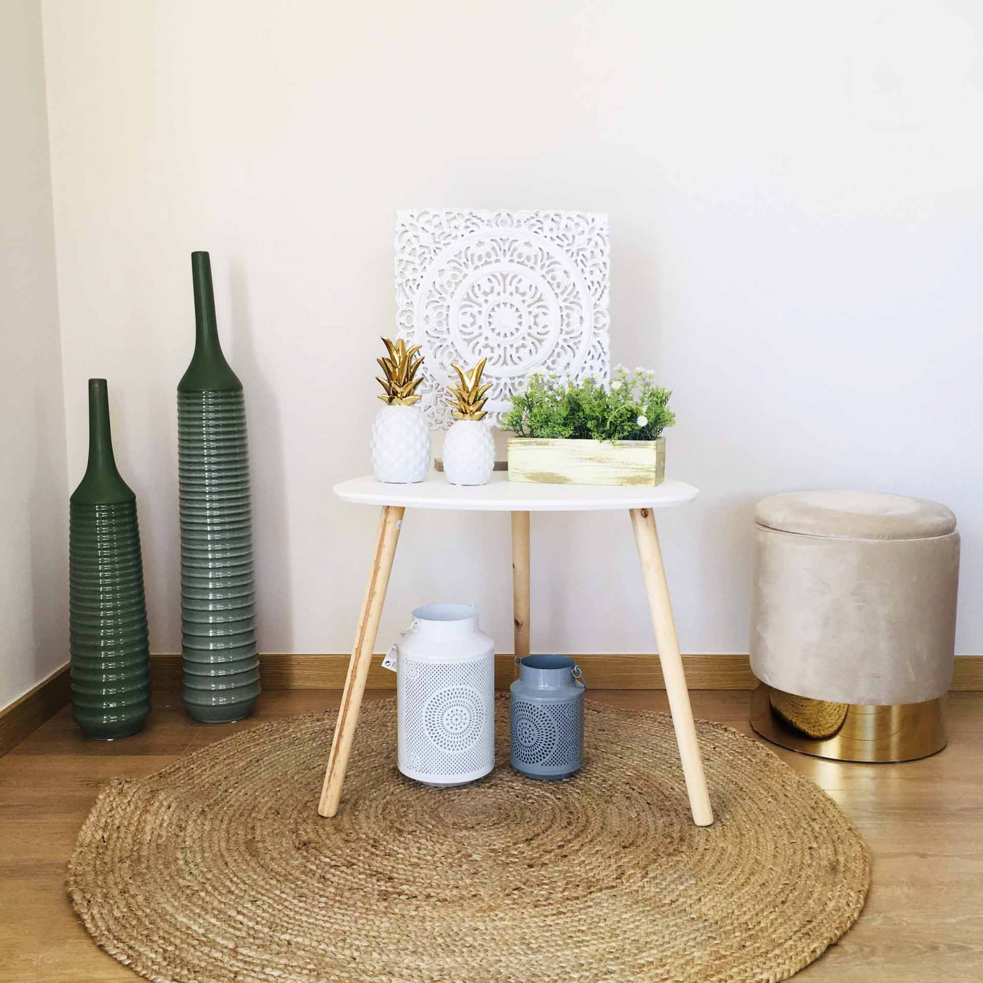 Mesa branca redonda com decoração em ambiente minimalista e tapete redondo de ráfia