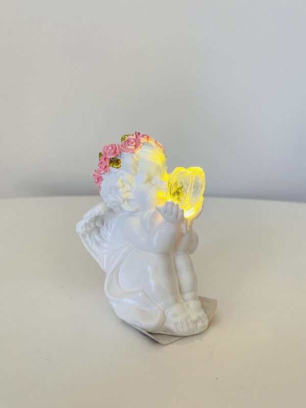 Anjo branco com coroa de flores e coração iluminado amarelo