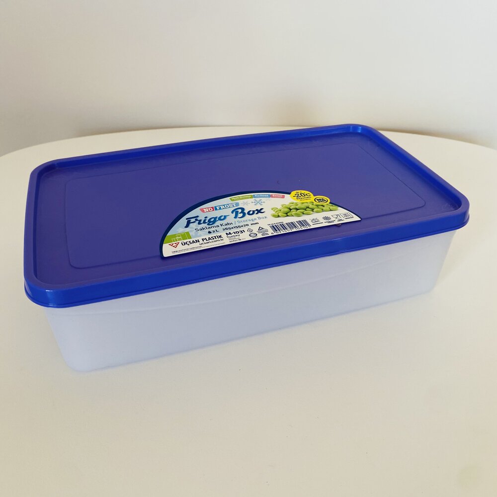 Caixa plástica transparente com tampa azul com etiqueta Pingo Box sobre superfície branca