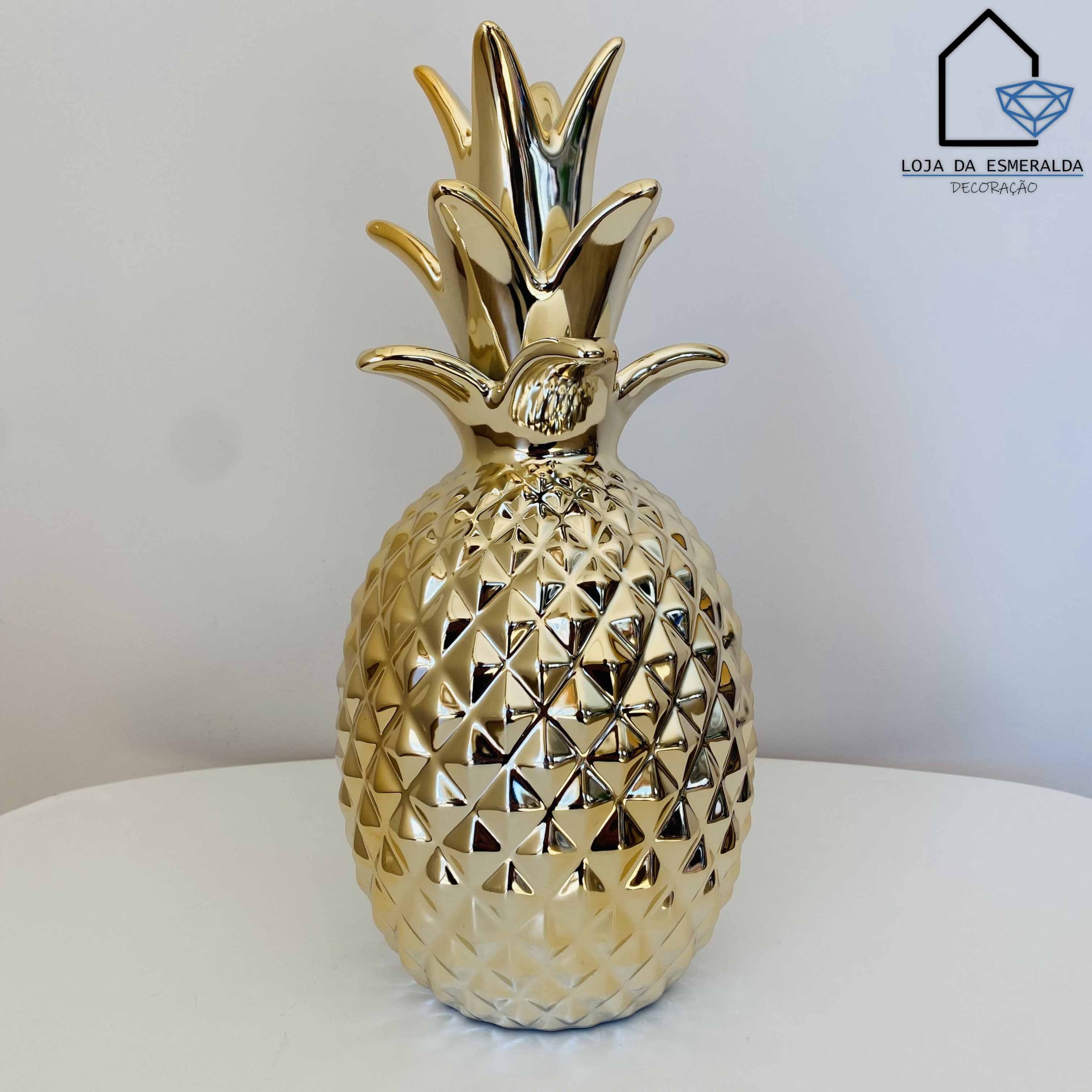 Escultura dourada em formato de ananás com textura facetada