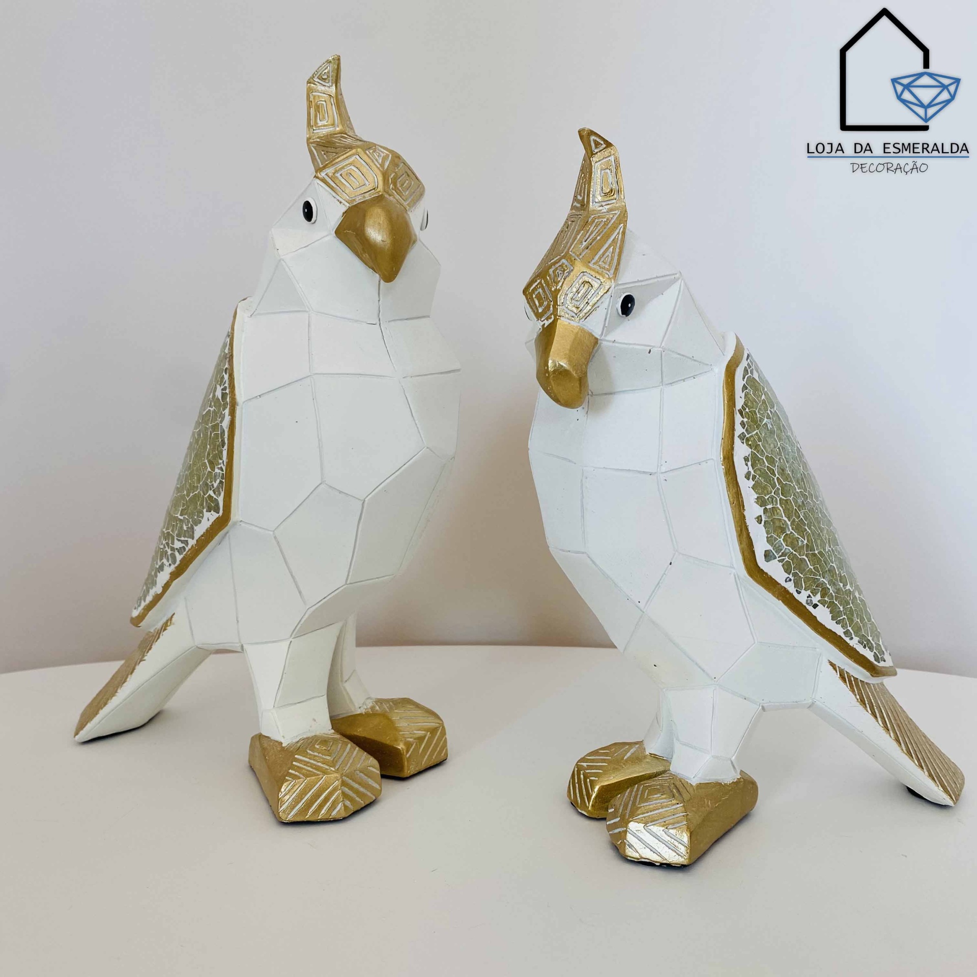 Esculturas decorativas de pássaros brancos e dourados com texturas nas asas e pés