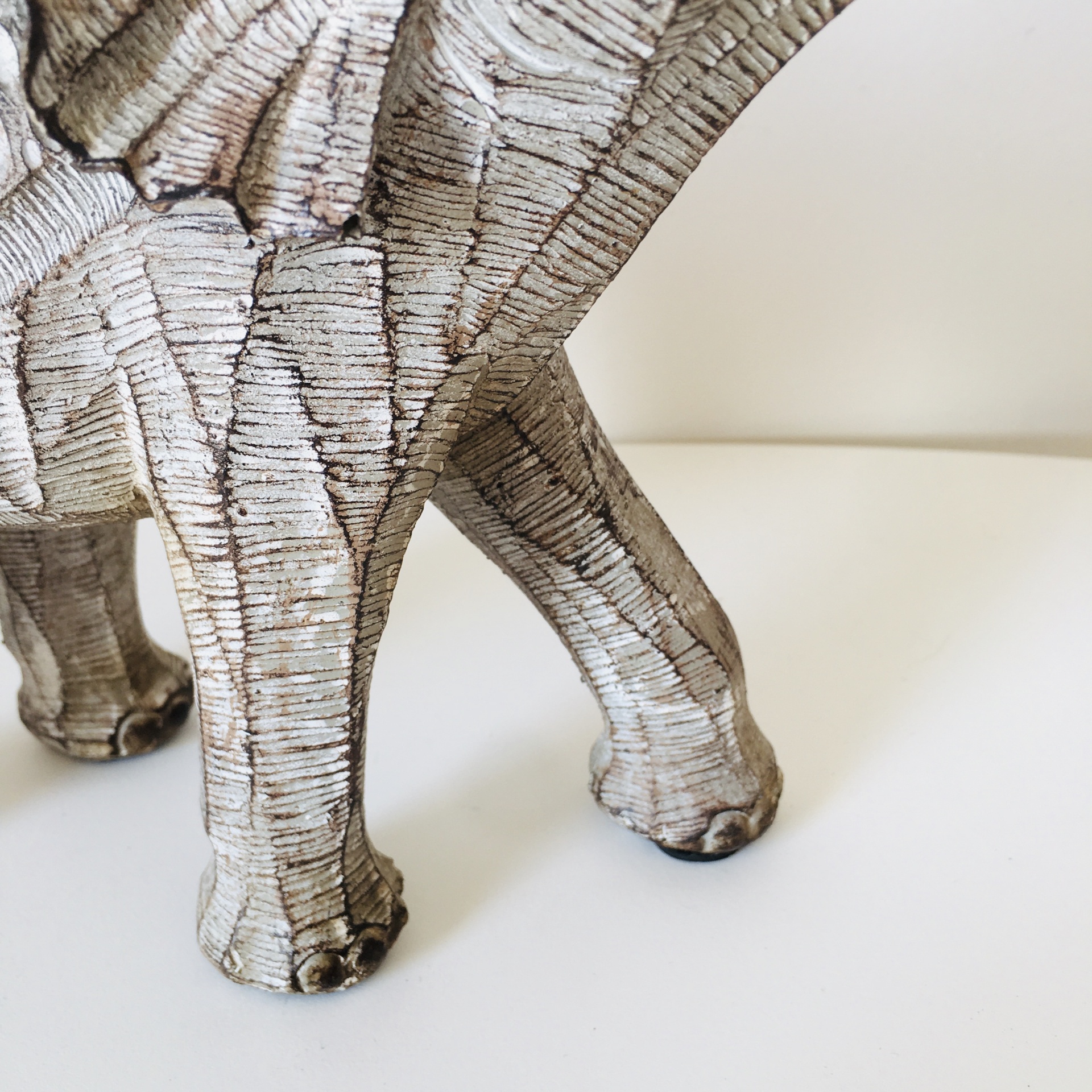 Estátua cerâmica de animal com textura estriada e cor bege com detalhes marrons