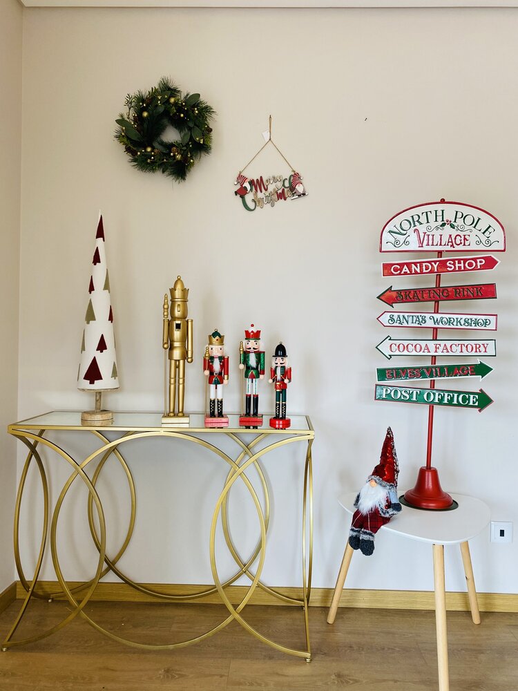 Decoração natalícia com soldadinhos de chumbo, árvore branca, placa do Pólo Norte e boneco de Natal sentado
