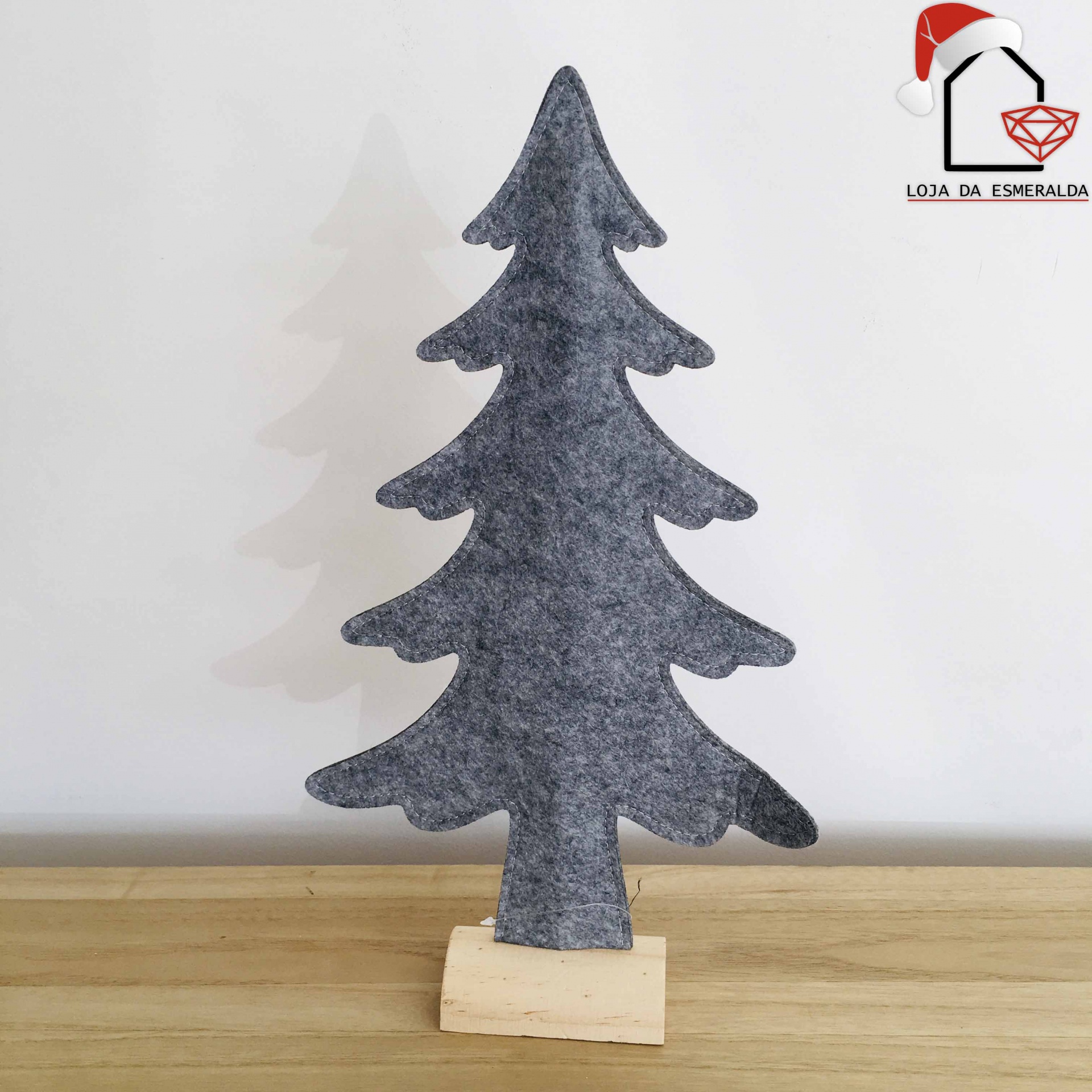 Árvore de Natal decorativa em feltro cinzento com base de madeira sobre mesa de madeira