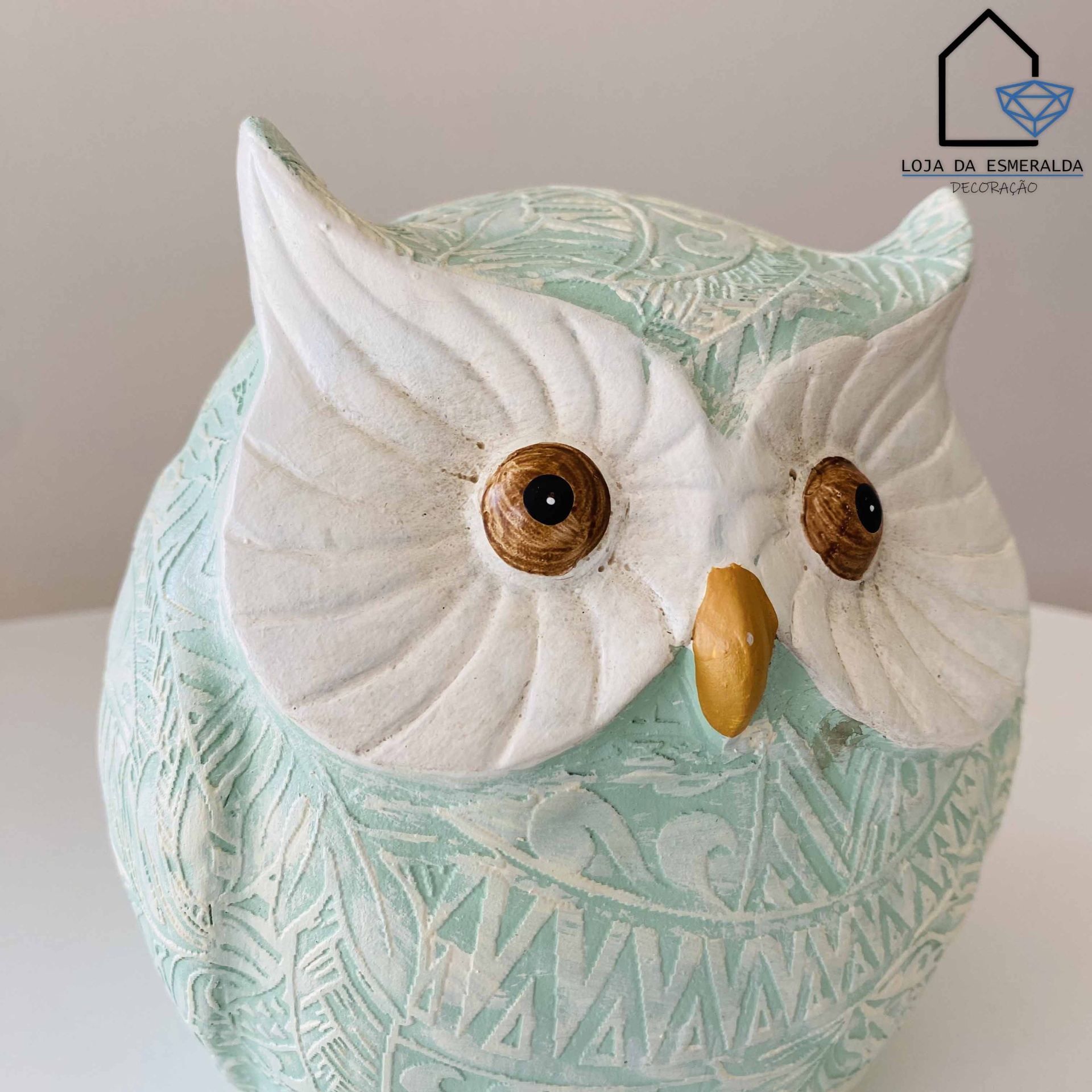 Escultura decorativa de coruja em cerâmica verde água com detalhes em branco e olhos castanhos