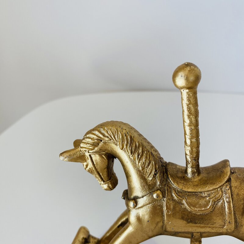 Estatueta dourada de cavalo em metal com suporte vertical