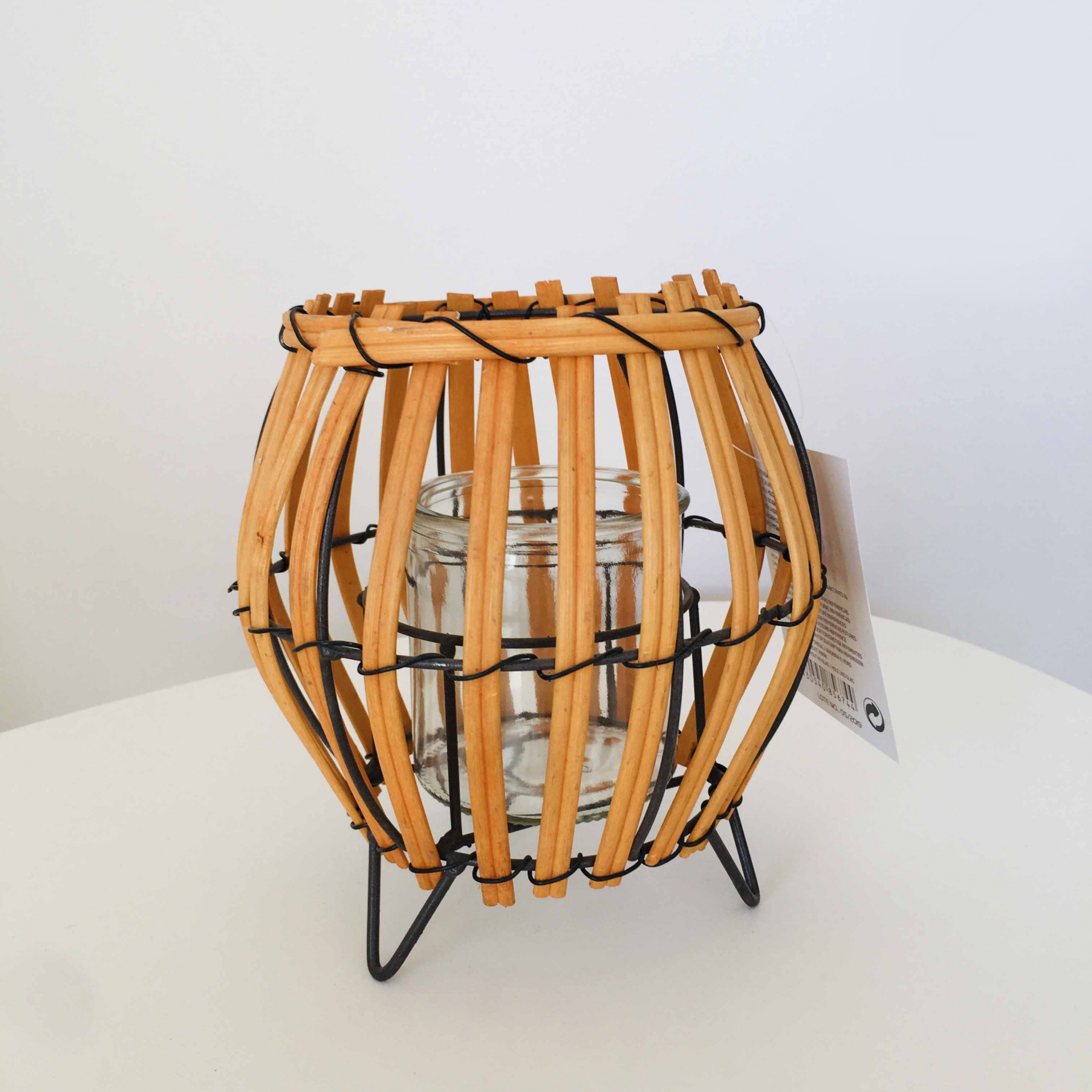 Lanterna decorativa em vime castanho com estrutura metálica preta e vidro transparente