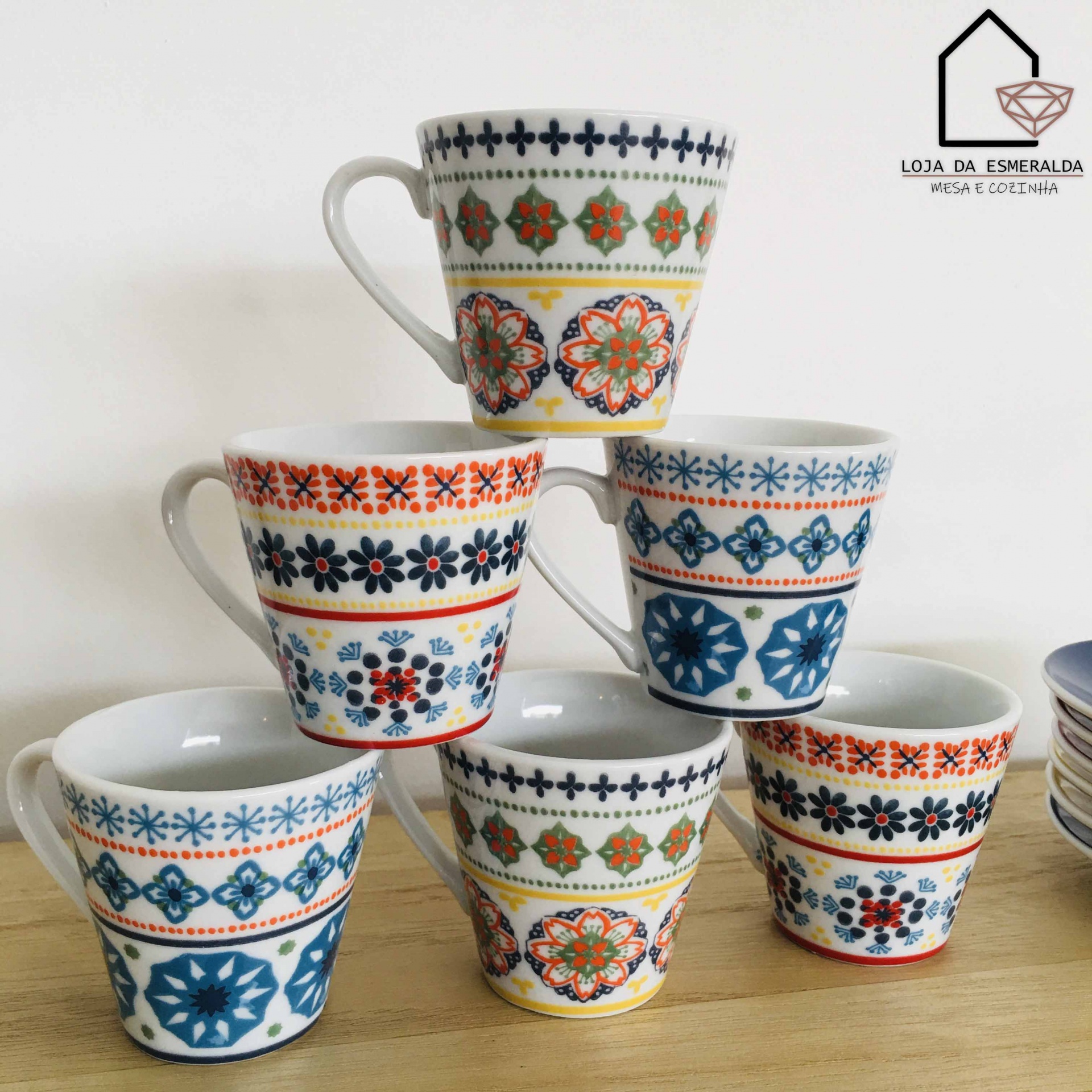 Seis chávenas de café com padrões coloridos, dispostas em pirâmide