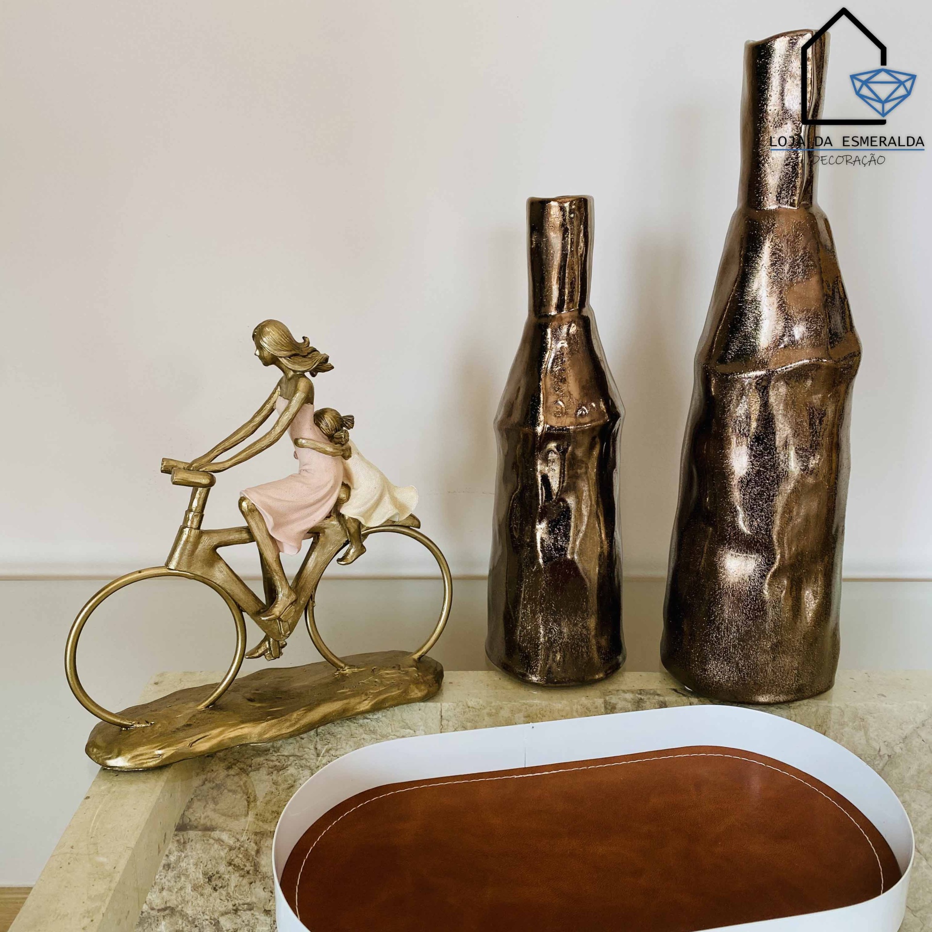 Escultura de mulher em bicicleta e vasos decorativos em dourado com bandeja oval branca e castanha