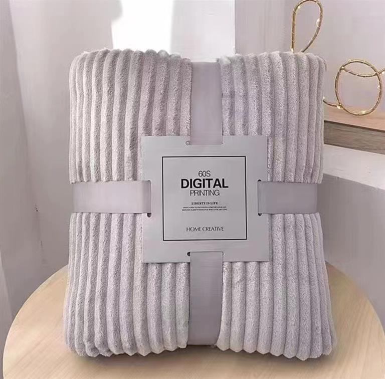 Cobertor cinzento com padrão de riscas verticais empacotado com rótulo branco